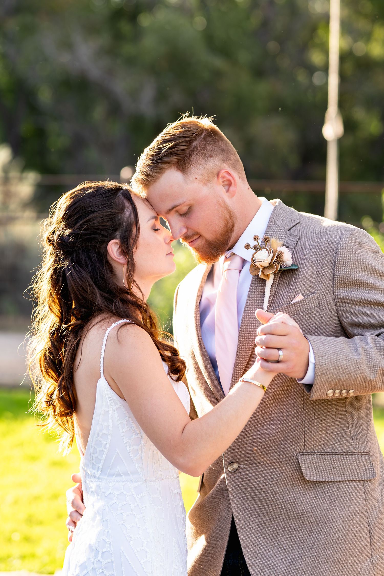 Romantic moment shared between couple in wedding attire during golden hour photography.