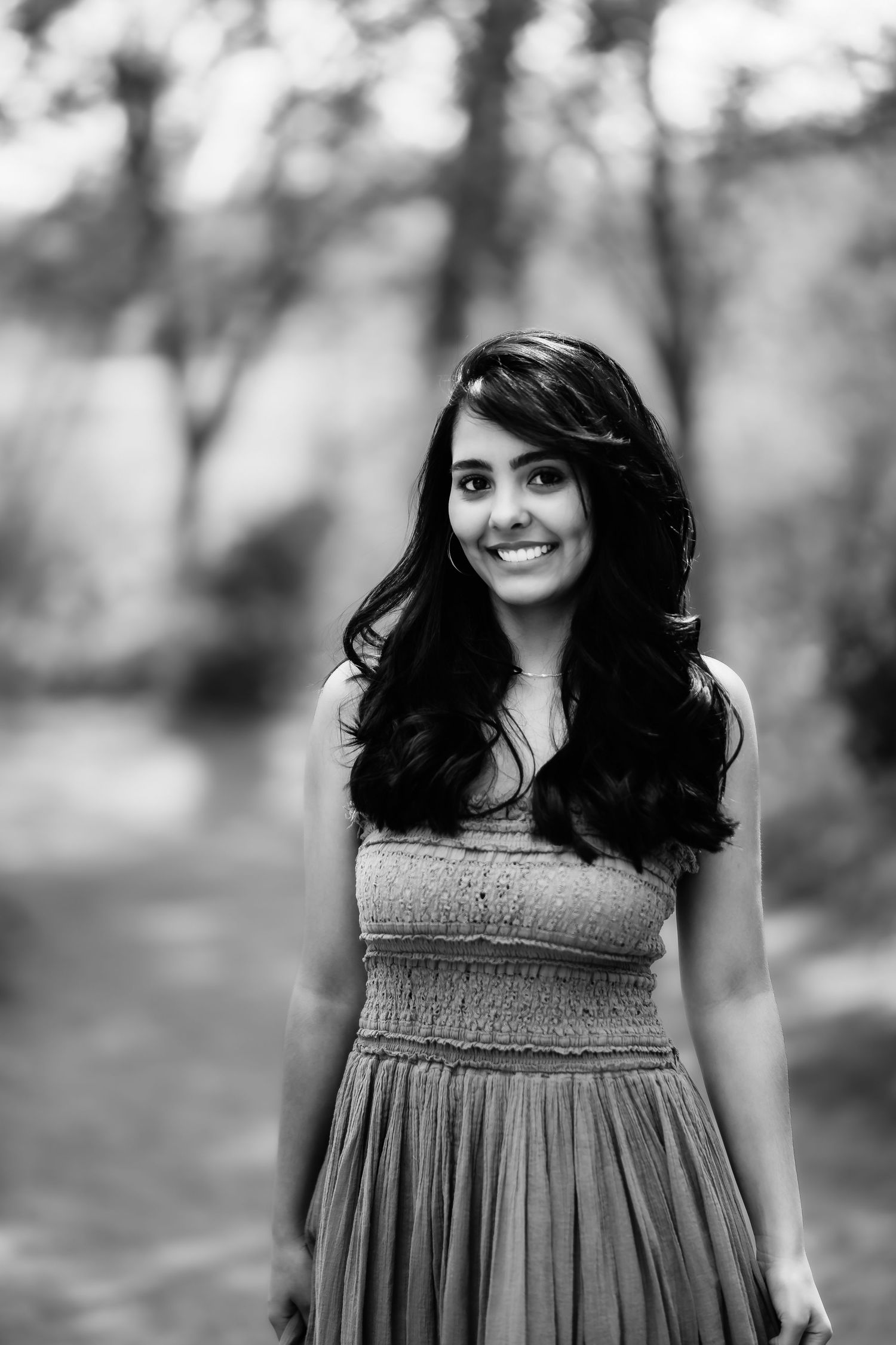 Black and white portrait showcasing natural beauty against a dreamy forest backdrop.
