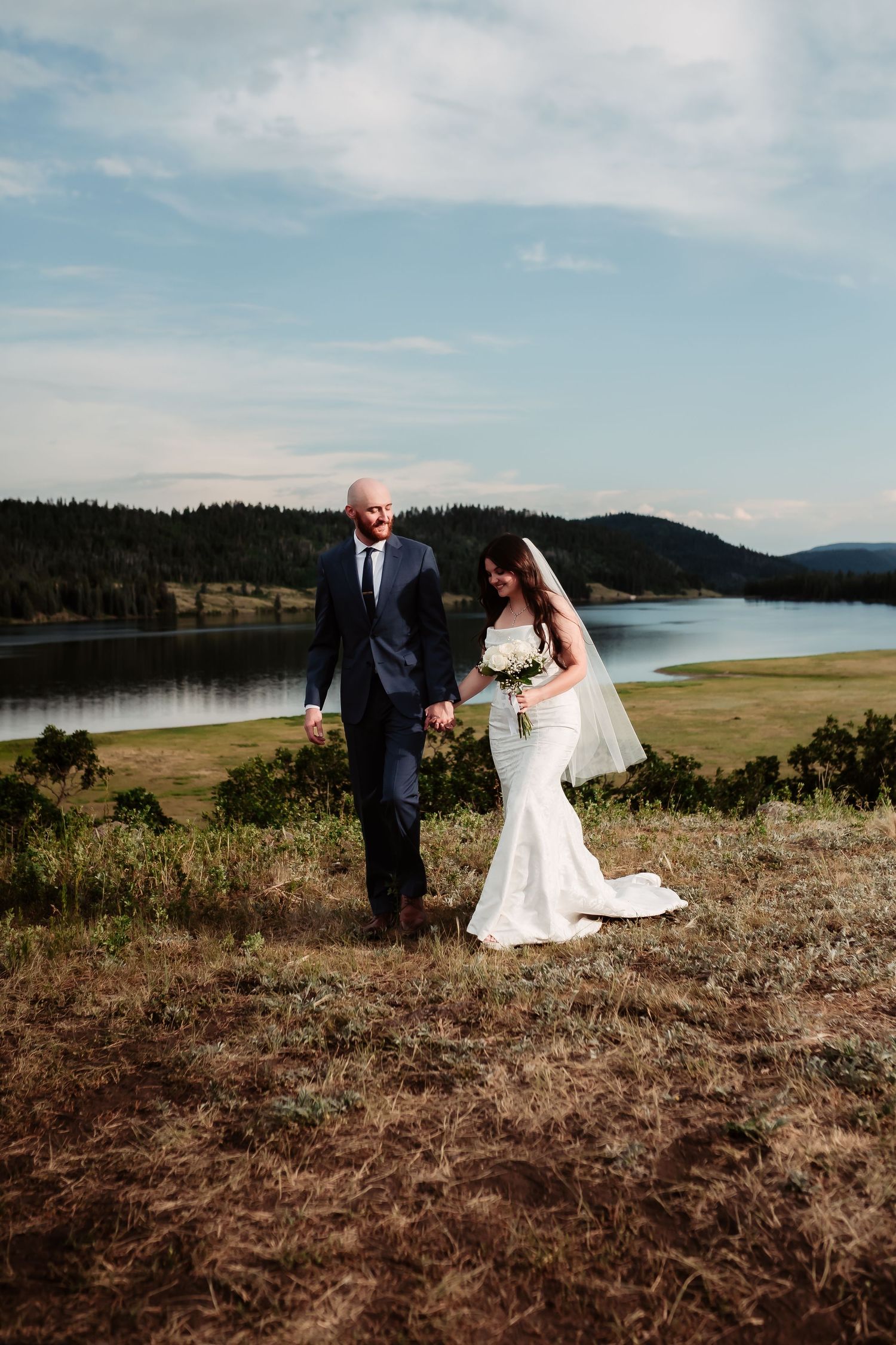 Scenic outdoor wedding photos overlooking a serene lake with mountain views.