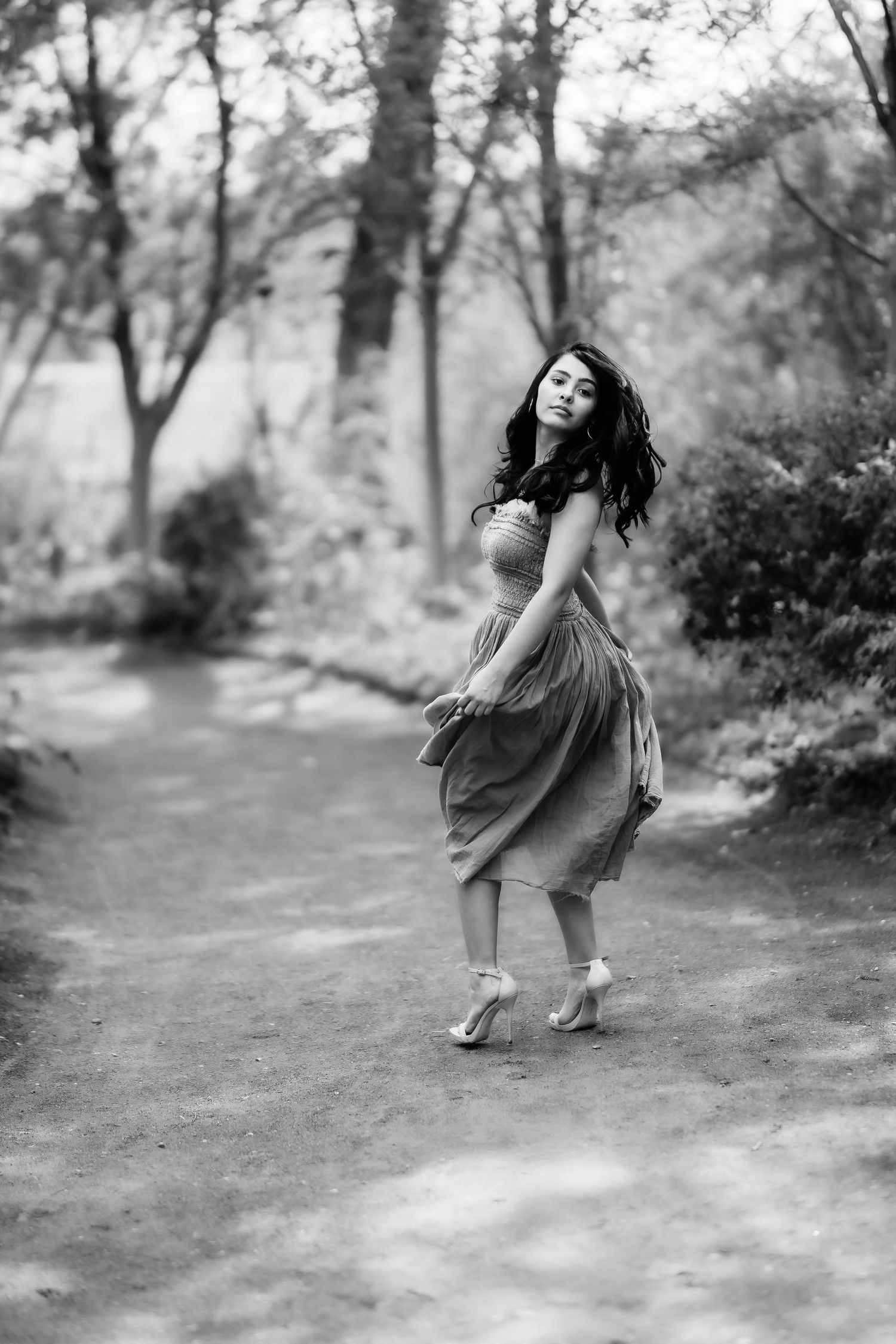 A dreamy black and white portrait of dancing in a wooded park setting.