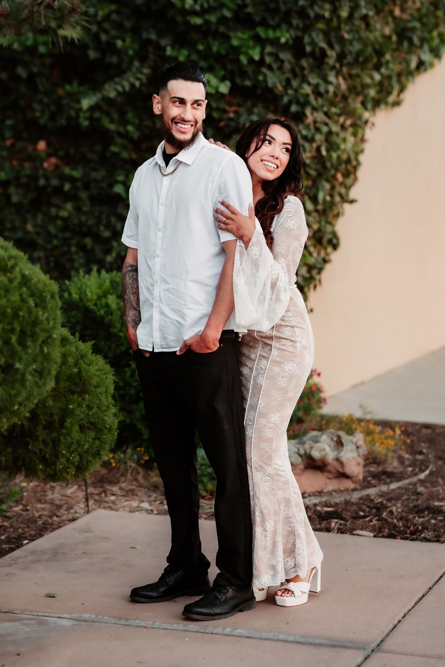 A casual outdoor portrait against ivy-covered walls and landscaped garden.