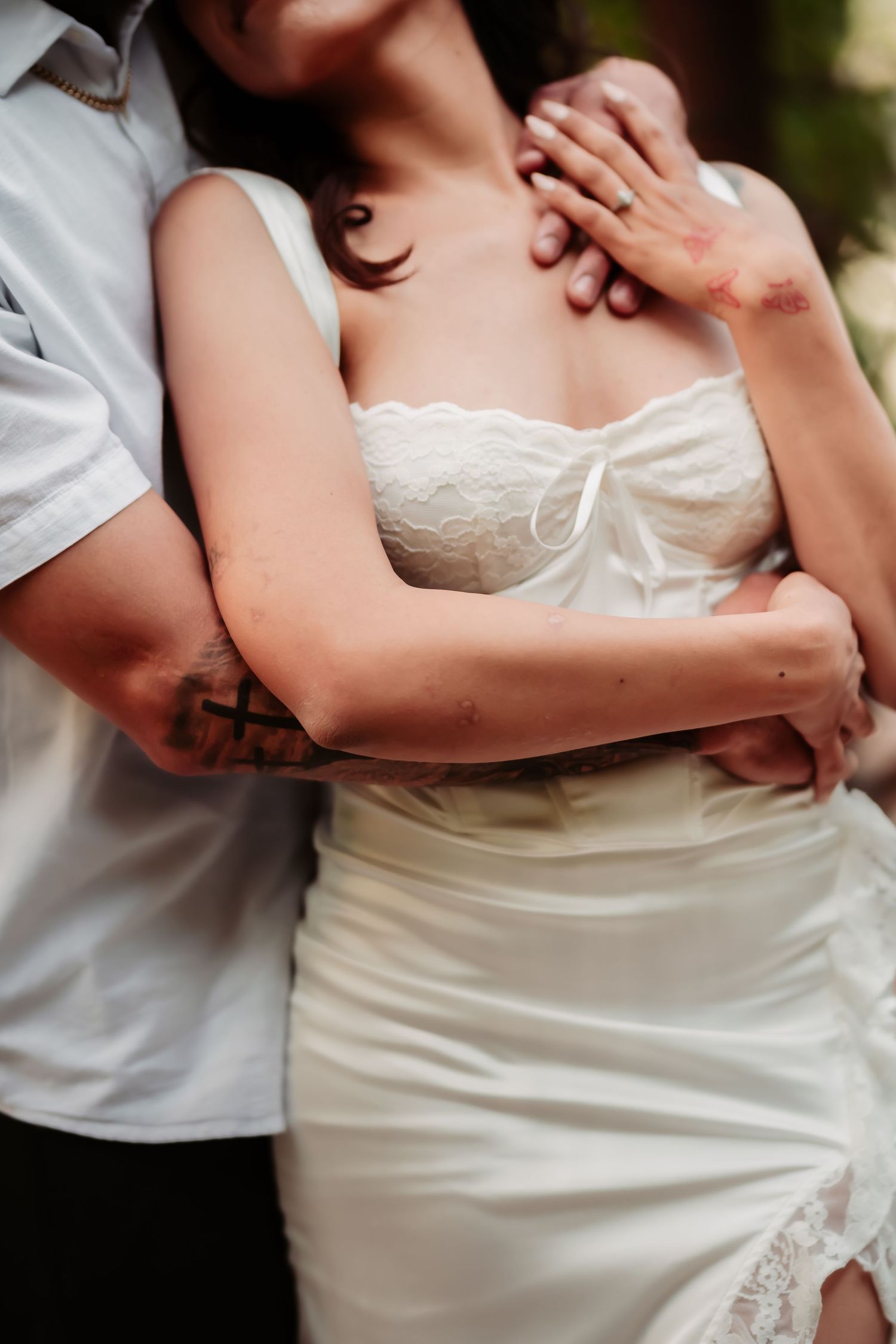 Close up of couple embracing in white attire showing romantic connection.