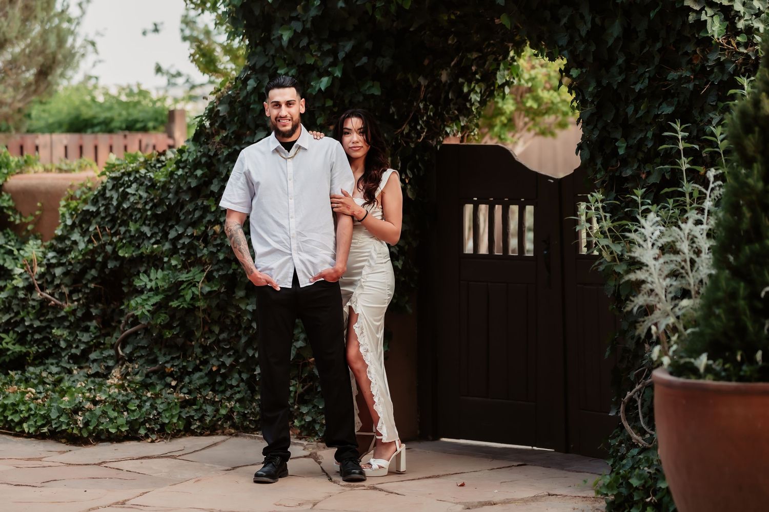 A romantic outdoor photo series showing a couple near a rustic gate and stone pathway.