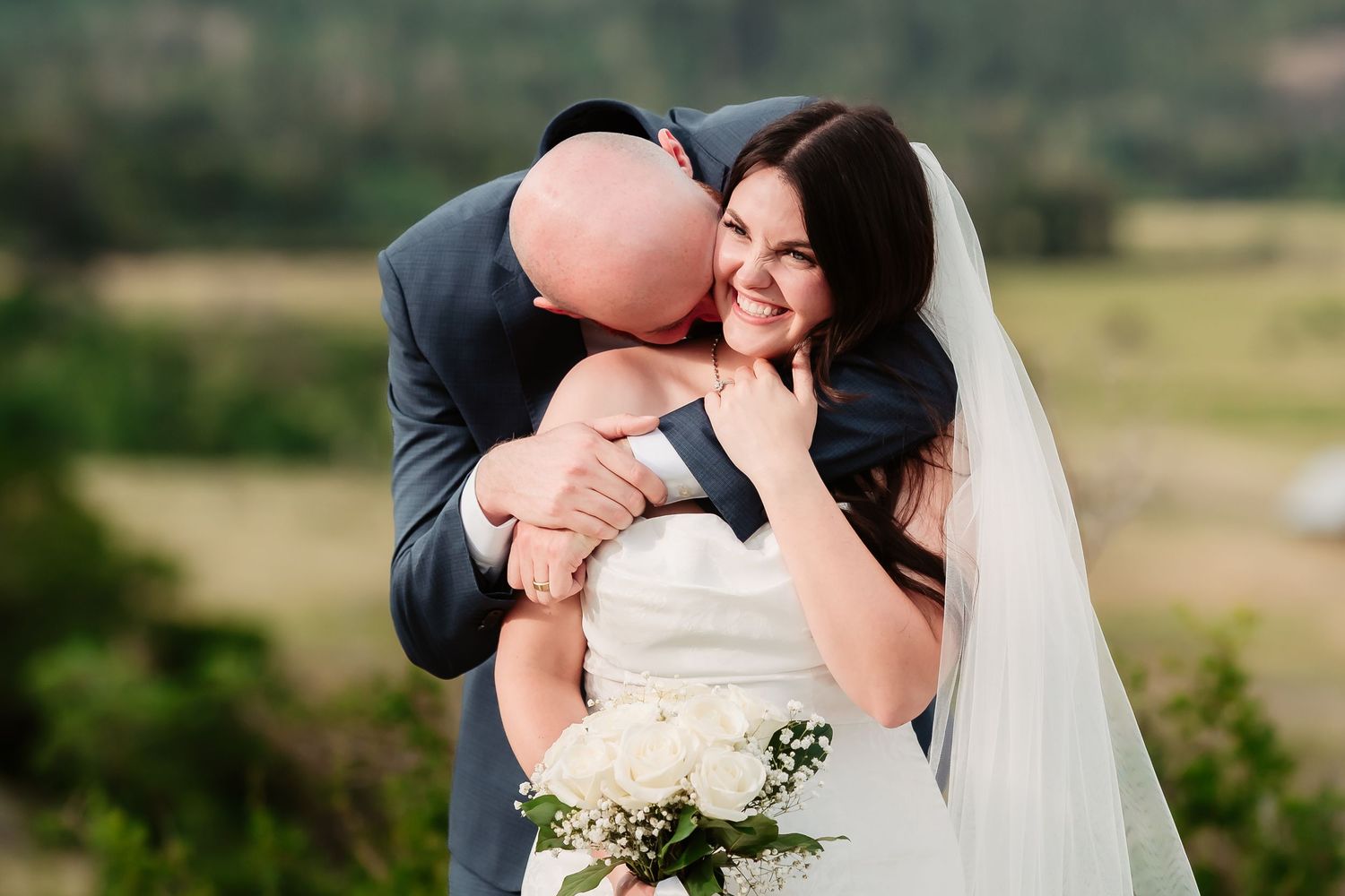 An intimate wedding moment captured against rolling mountain landscapes.