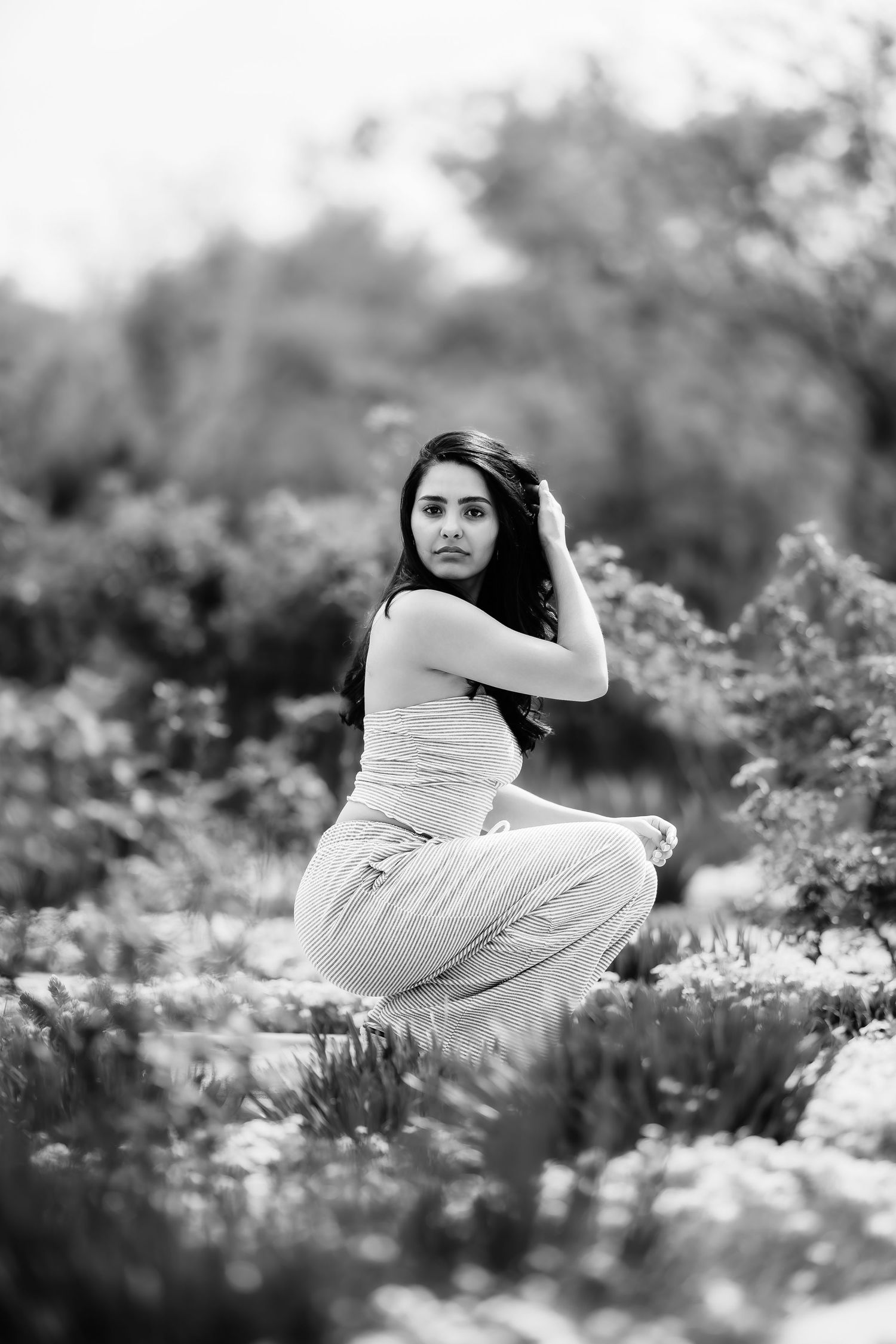 Black and white outdoor portrait in casual wear amid wild flowers.