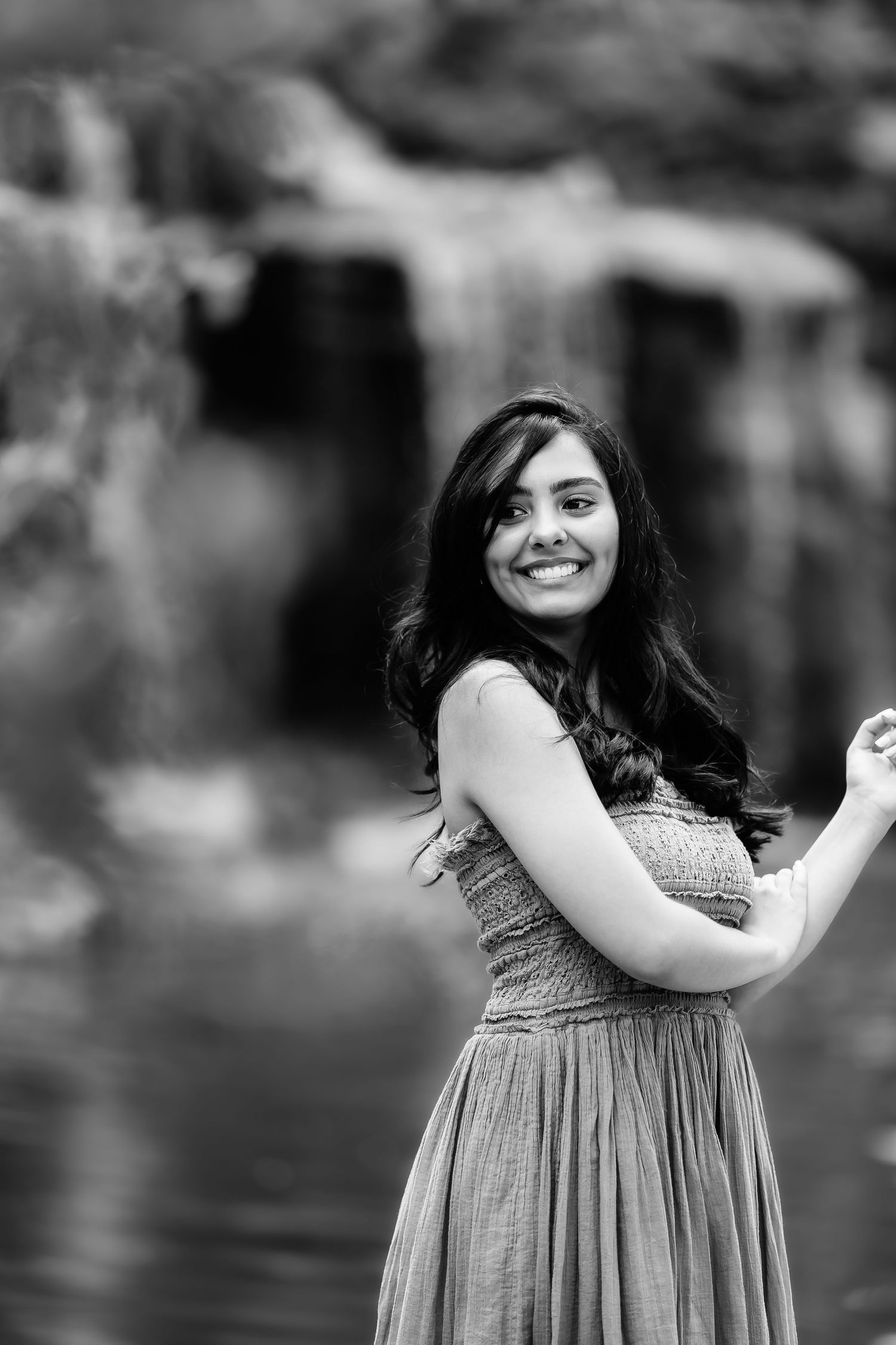 Black and white portrait by a waterfall showing joyful expression.