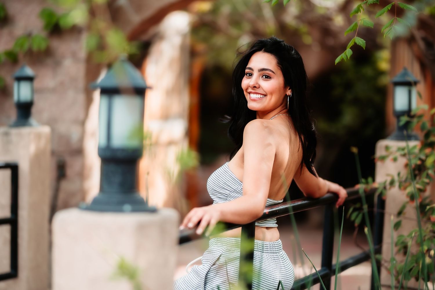 Candid moment captured by vintage lamp post with warm architectural background.