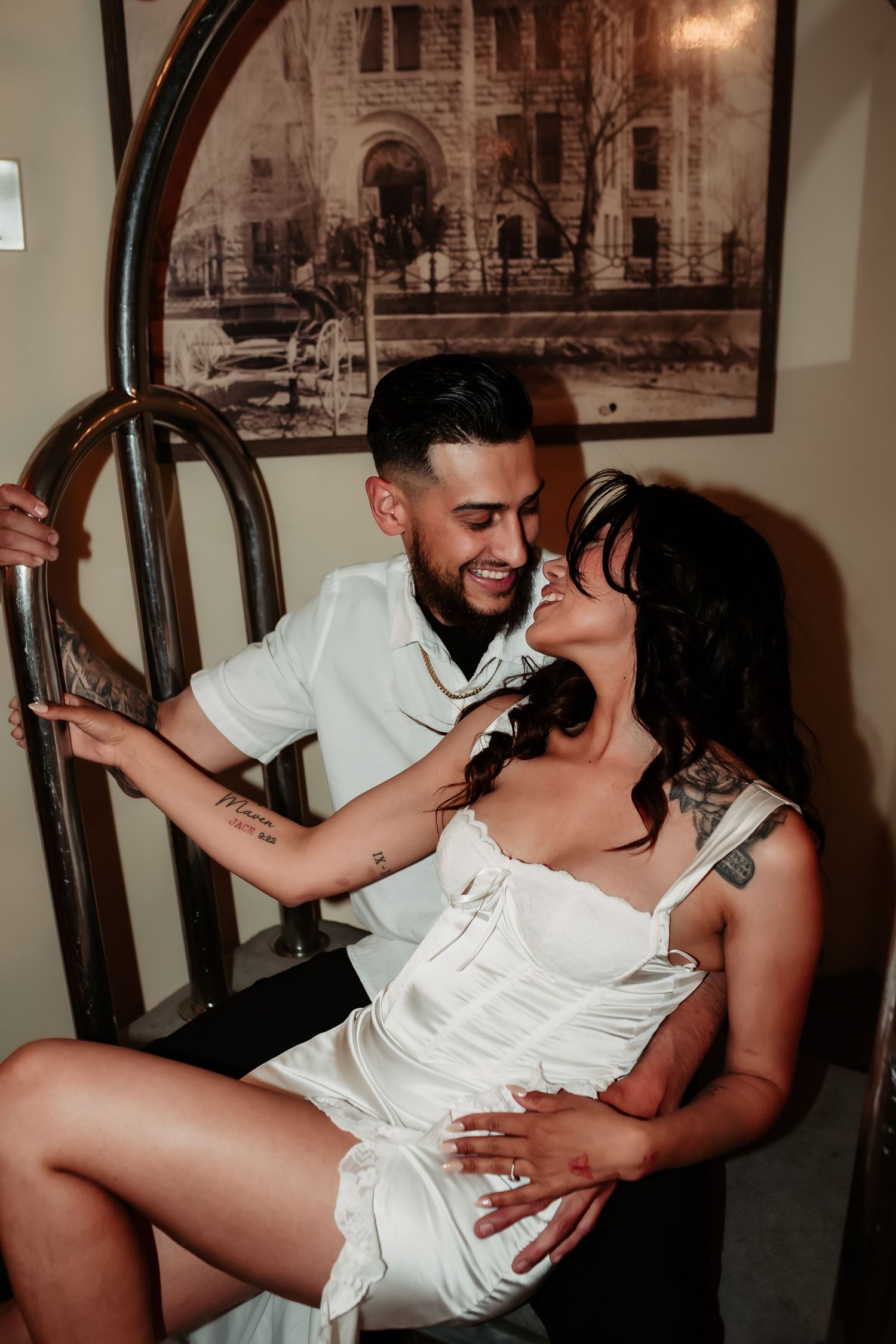 Stylish couple in vintage-inspired setting share playful moment against antique decor.