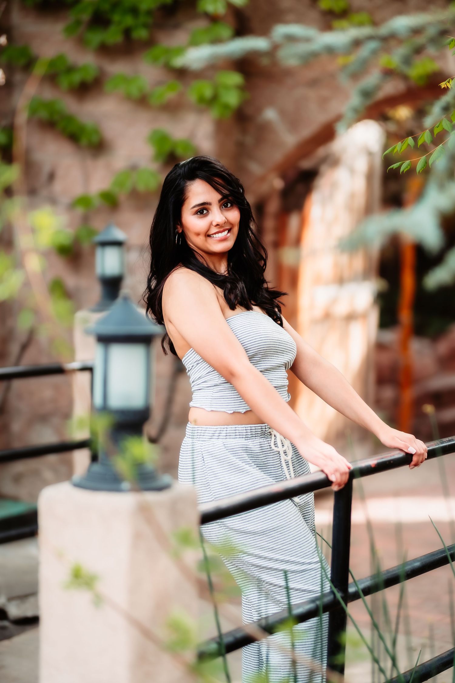 A stylish outfit photo showing grey matching loungewear set against an architectural backdrop with greenery.