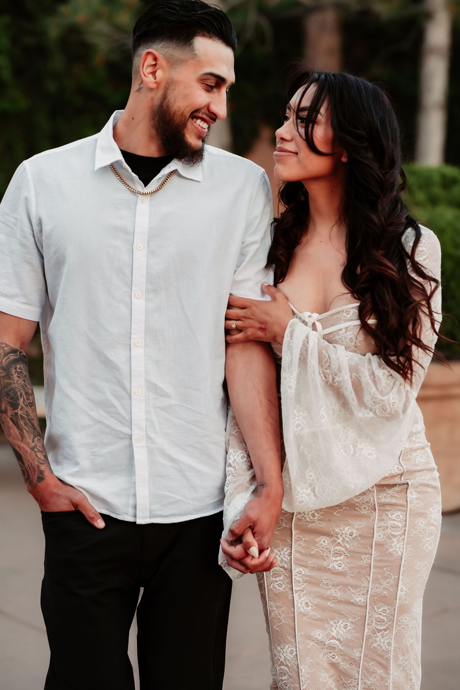 A romantic wedding photoshoot features close-up details of a lace bridal gown and white dress shirt in an outdoor setting.