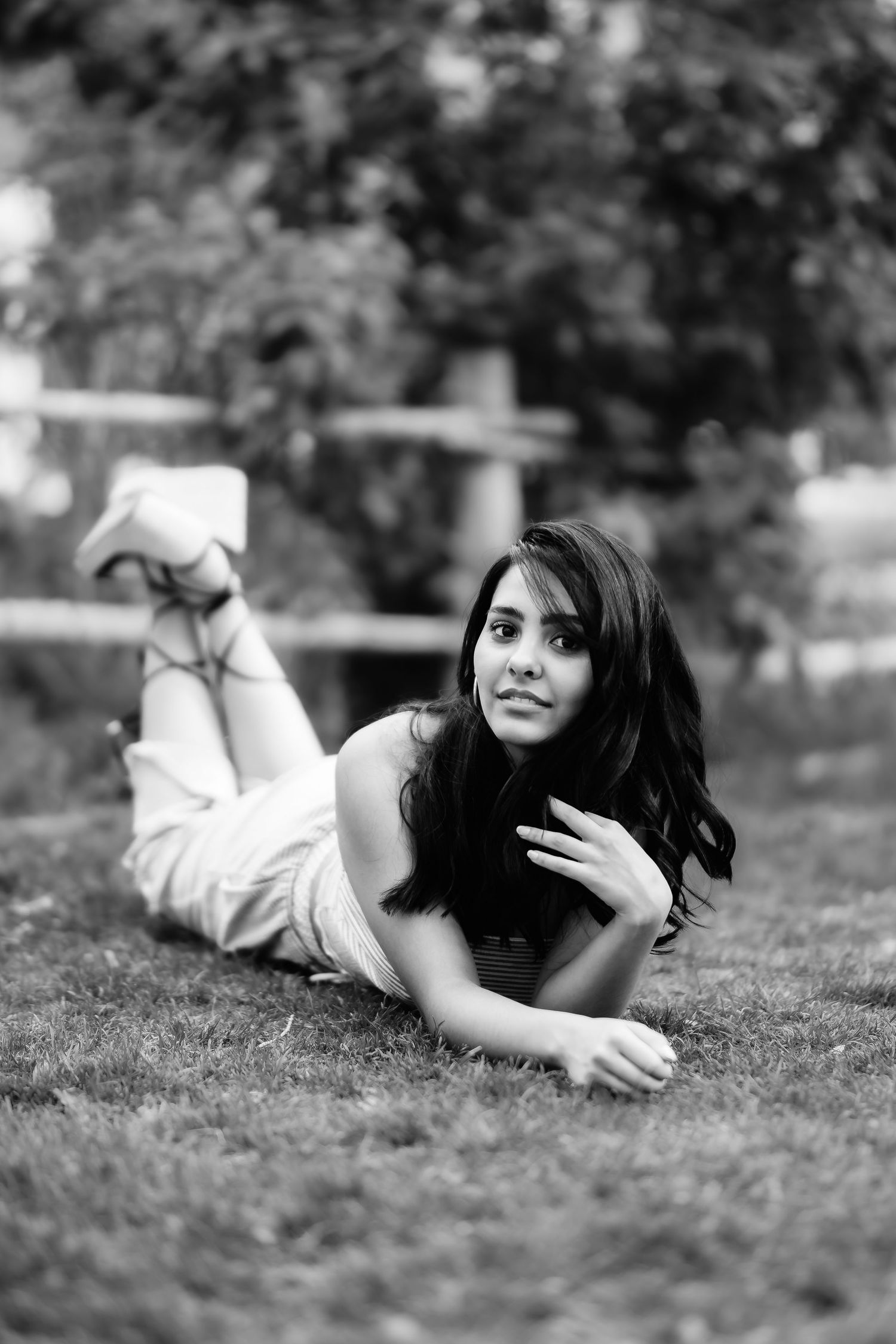Relaxed black and white portrait on grass with casual pose.