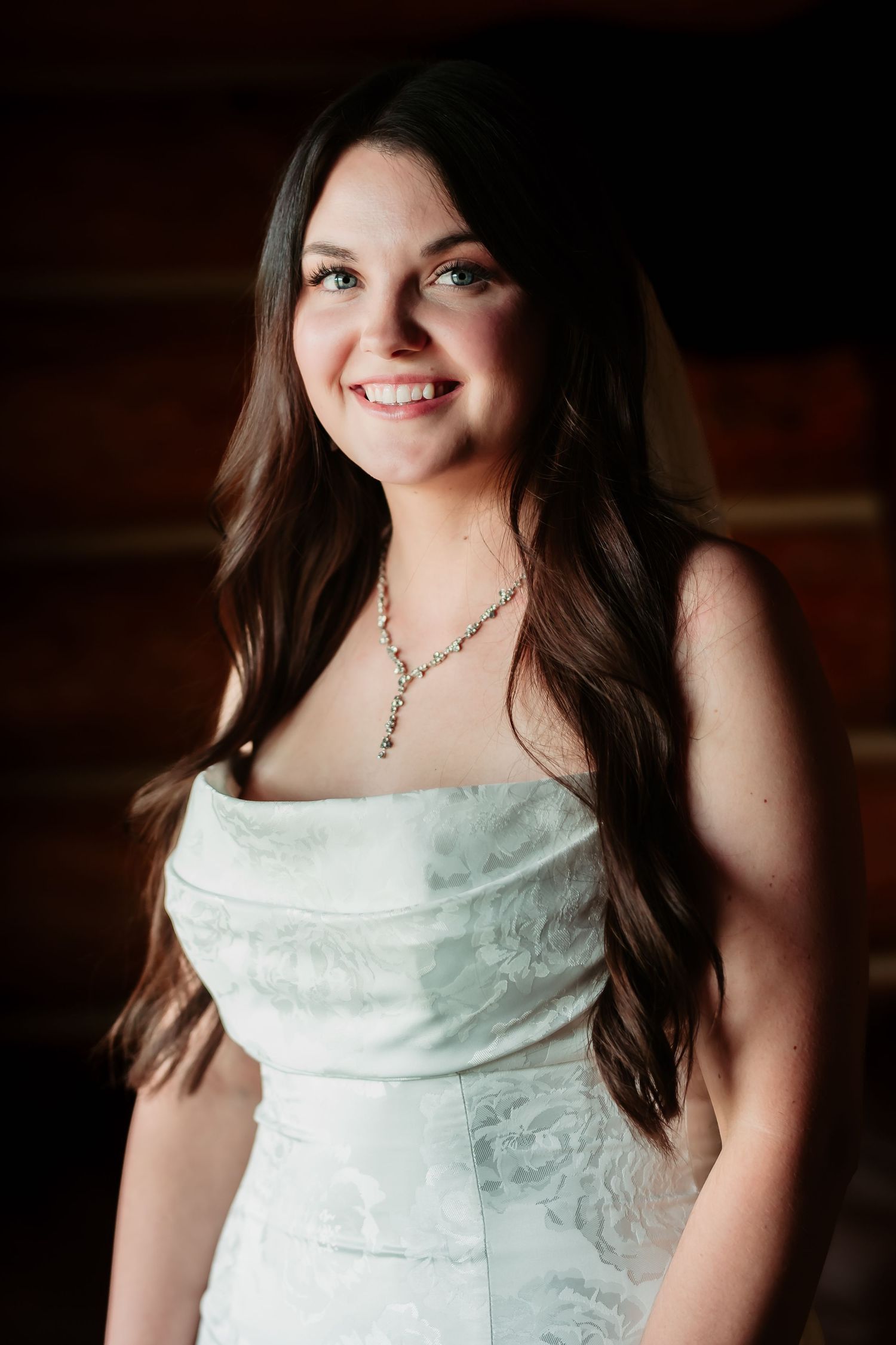 Close up portraits of someone in a white strapless wedding gown with delicate lace details.