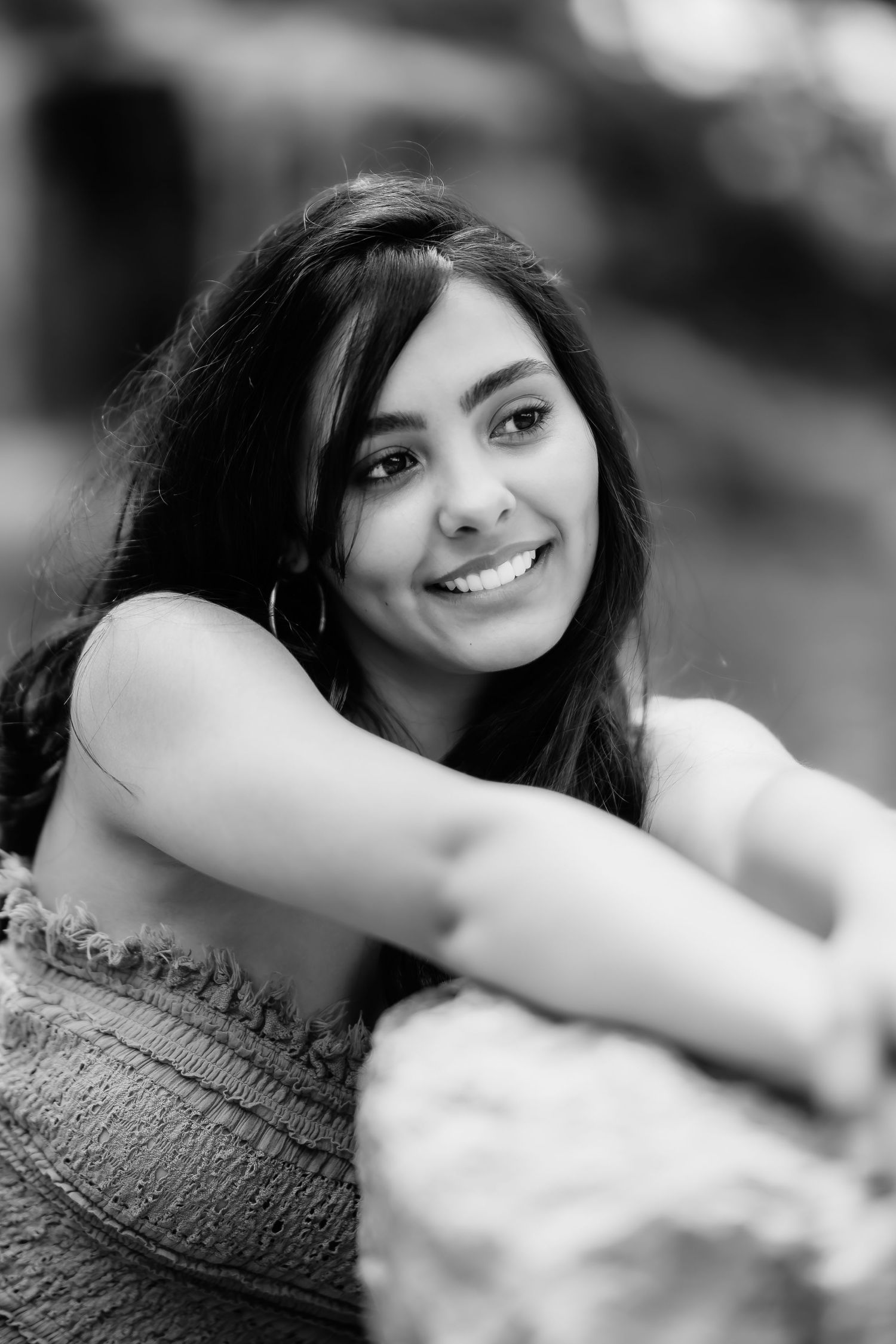 A casual black and white closeup portrait showing a warm expression and natural outdoor lighting.