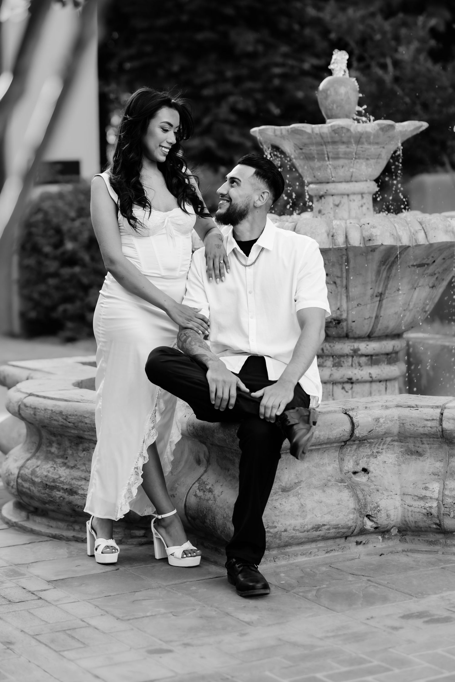 A romantic black and white photo shoot of a couple on stone steps.