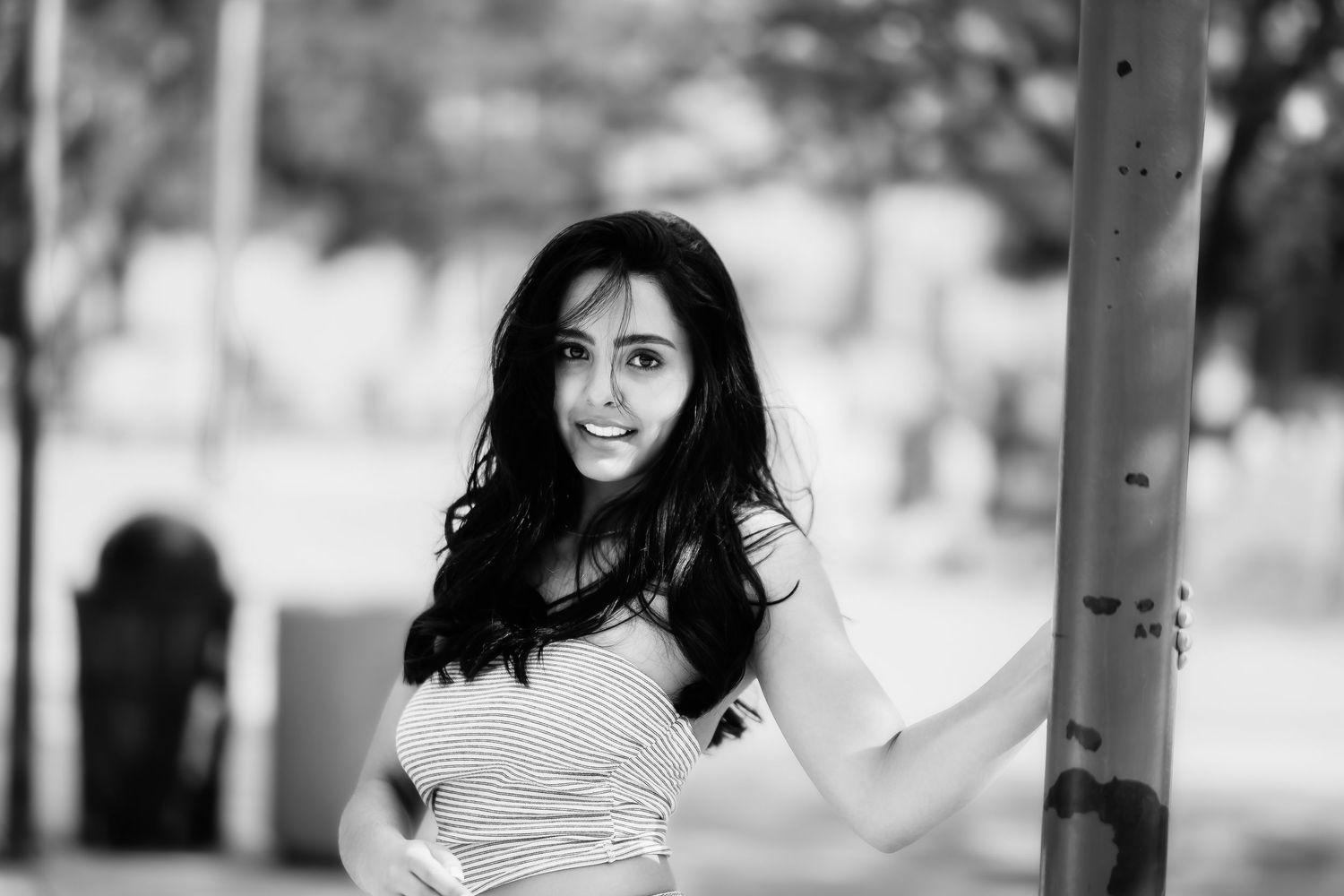 Black and white close-up portrait of woman with long dark hair and bright smile.