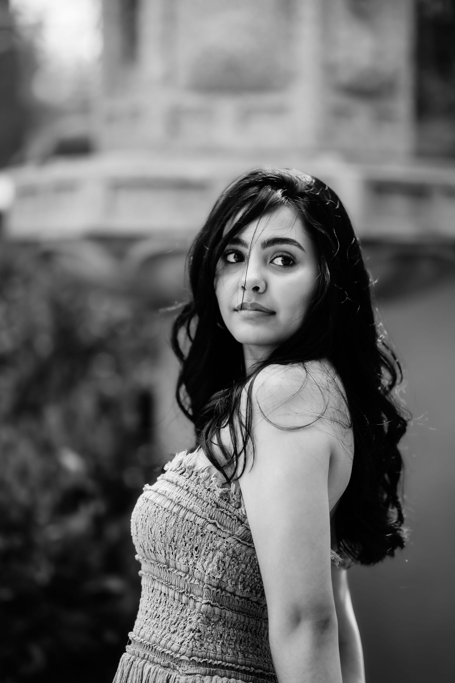 A black and white portrait showing long wavy hair and textured top.