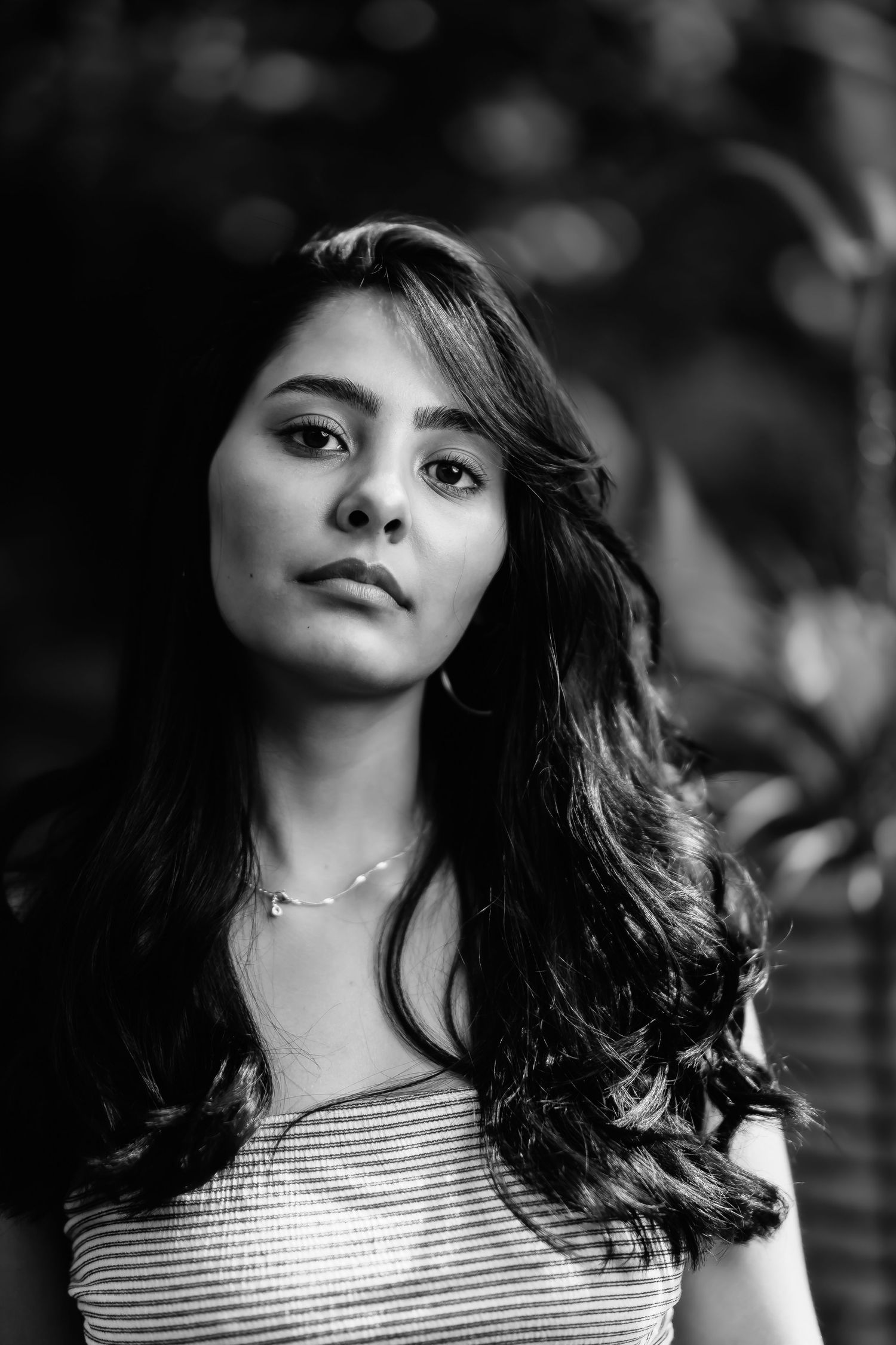 Dramatic black and white close-up portrait with natural lighting and striped top.
