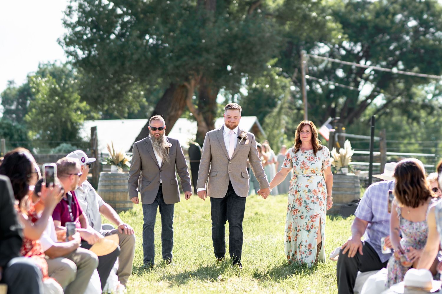 Guests mill about on a grassy lawn during an outdoor wedding ceremony.