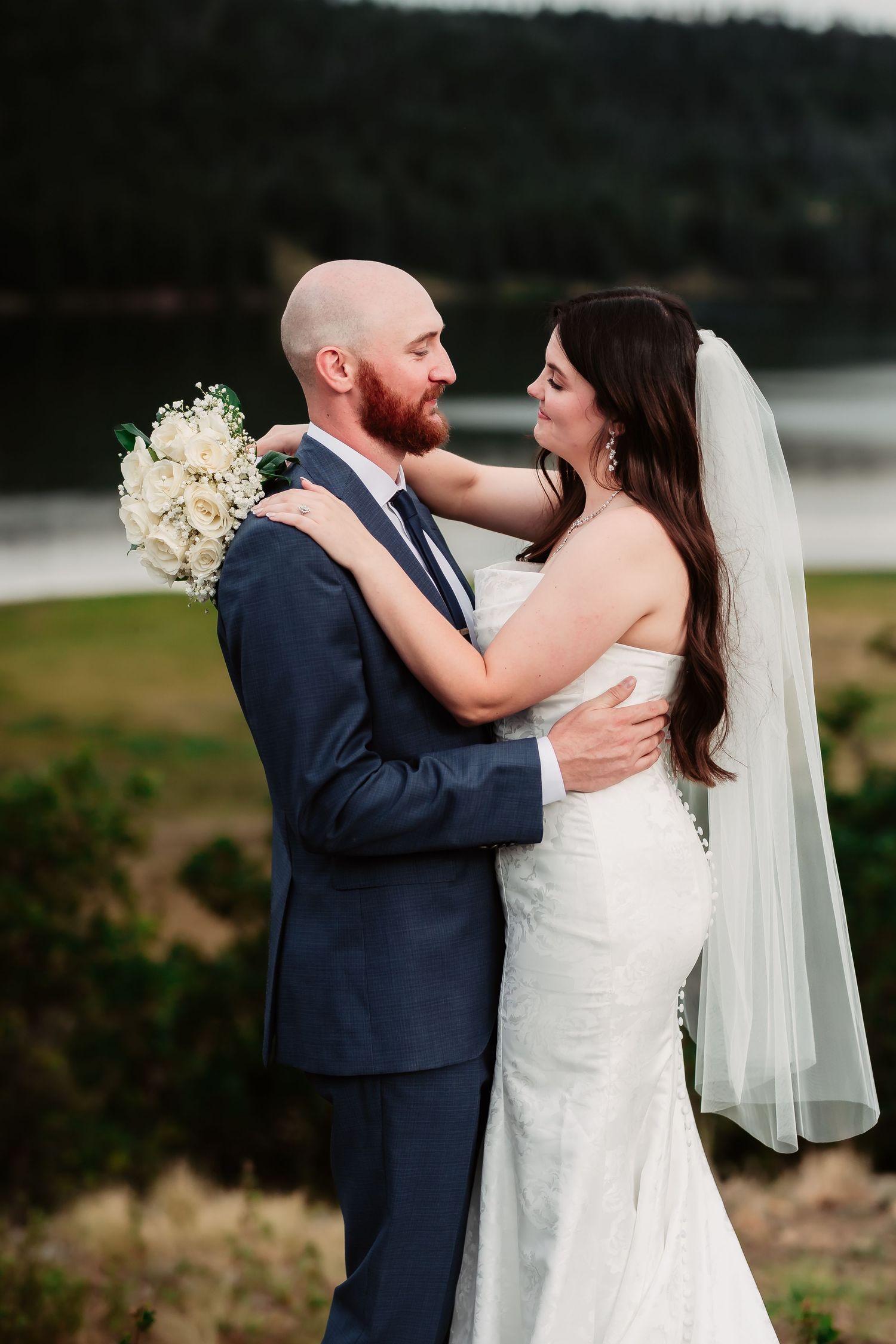 Newlyweds share an intimate moment during their outdoor mountain wedding photoshoot.