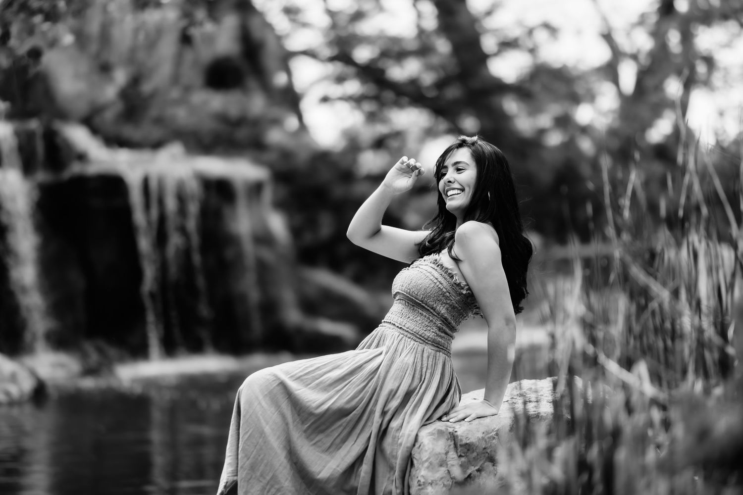 Dramatic black and white portrait by a waterfall in a flowing dress.