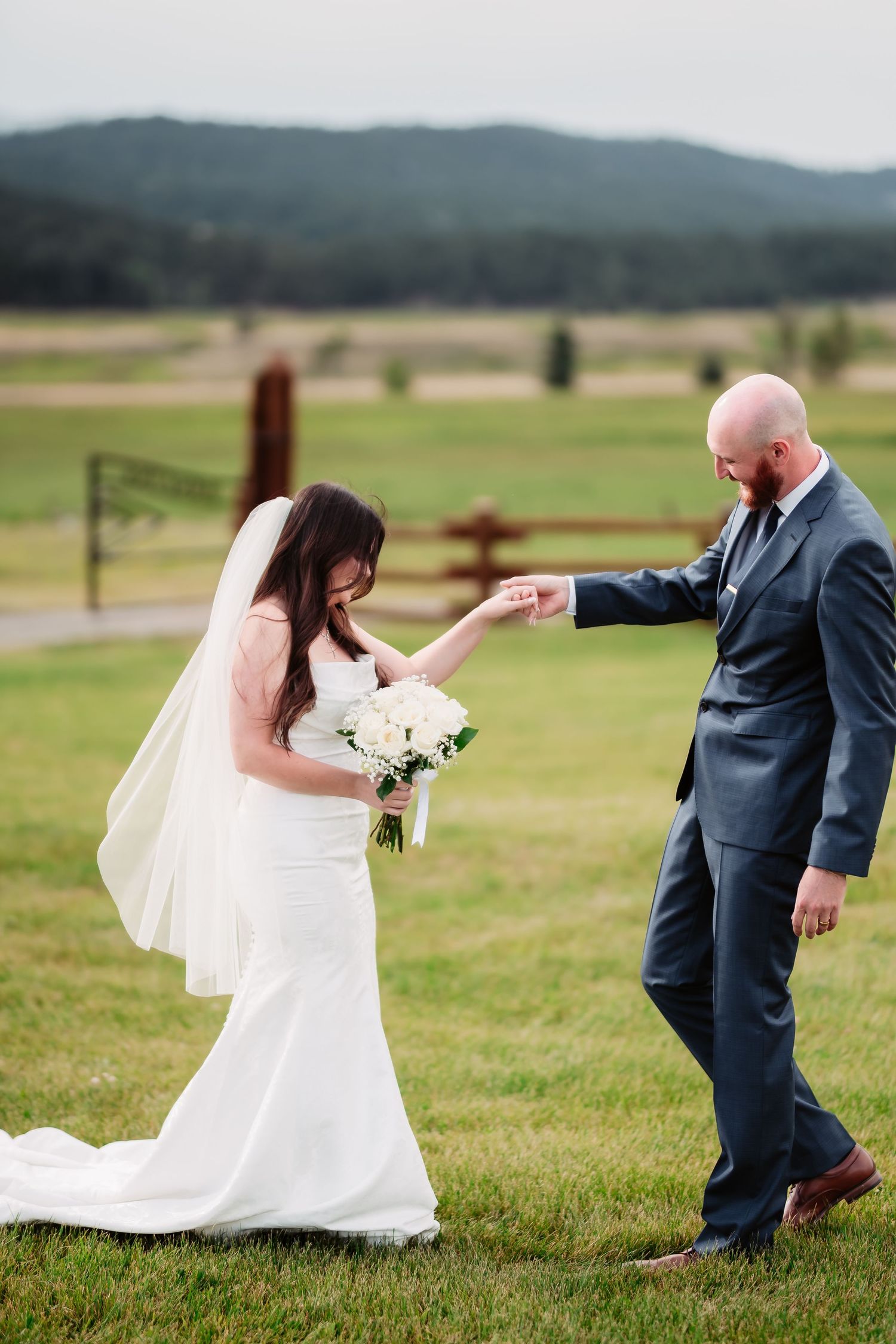 Playful wedding photo sequence showing couple dancing in a grassy field with mountains behind.