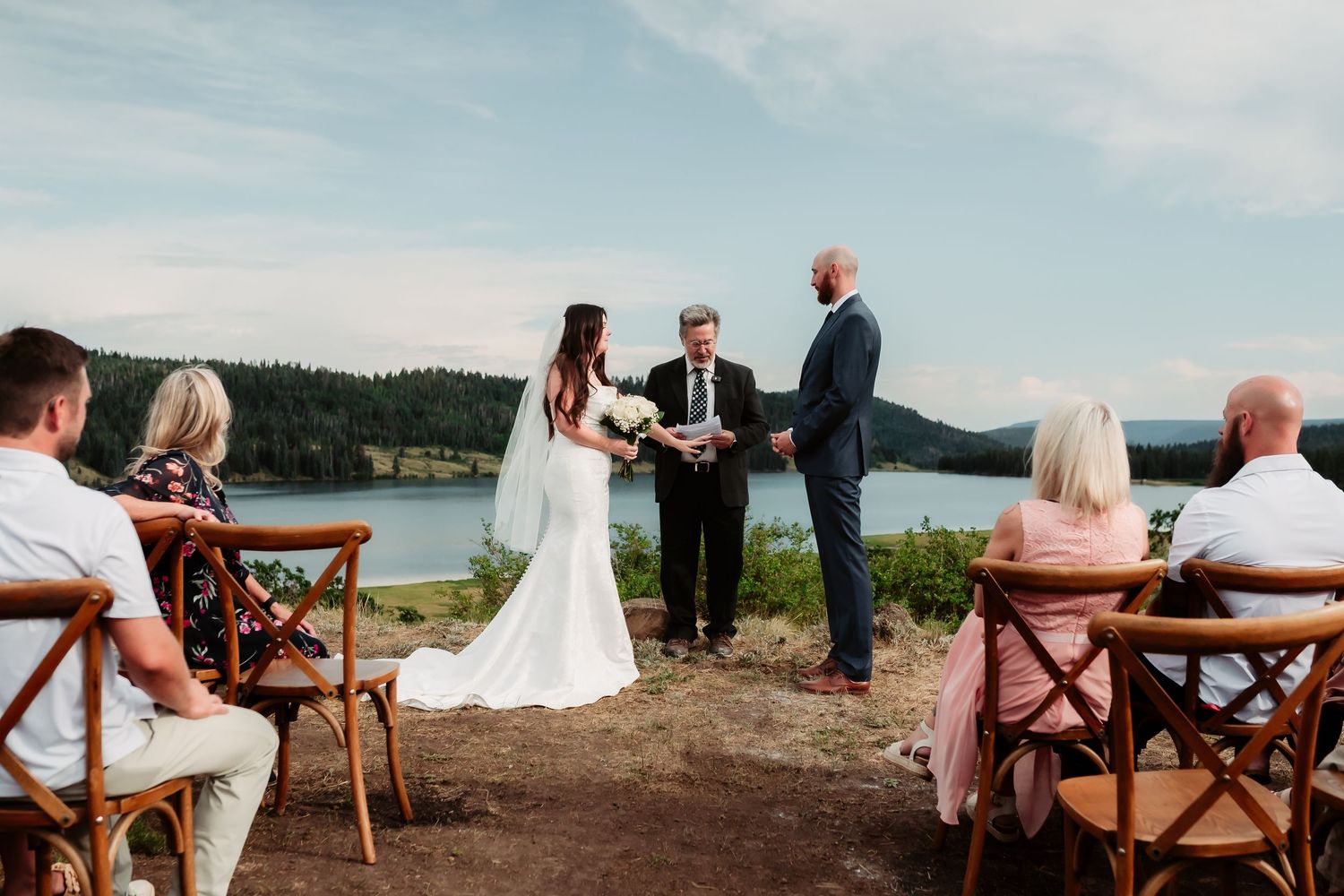 Panoramic view of outdoor wedding reception seating with mountain vistas in the background.