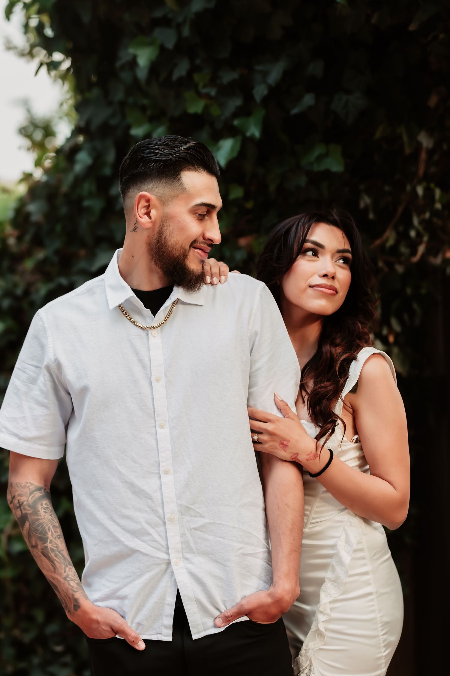 An intimate portrait session showing a couple embracing while wearing coordinated formal attire outdoors.