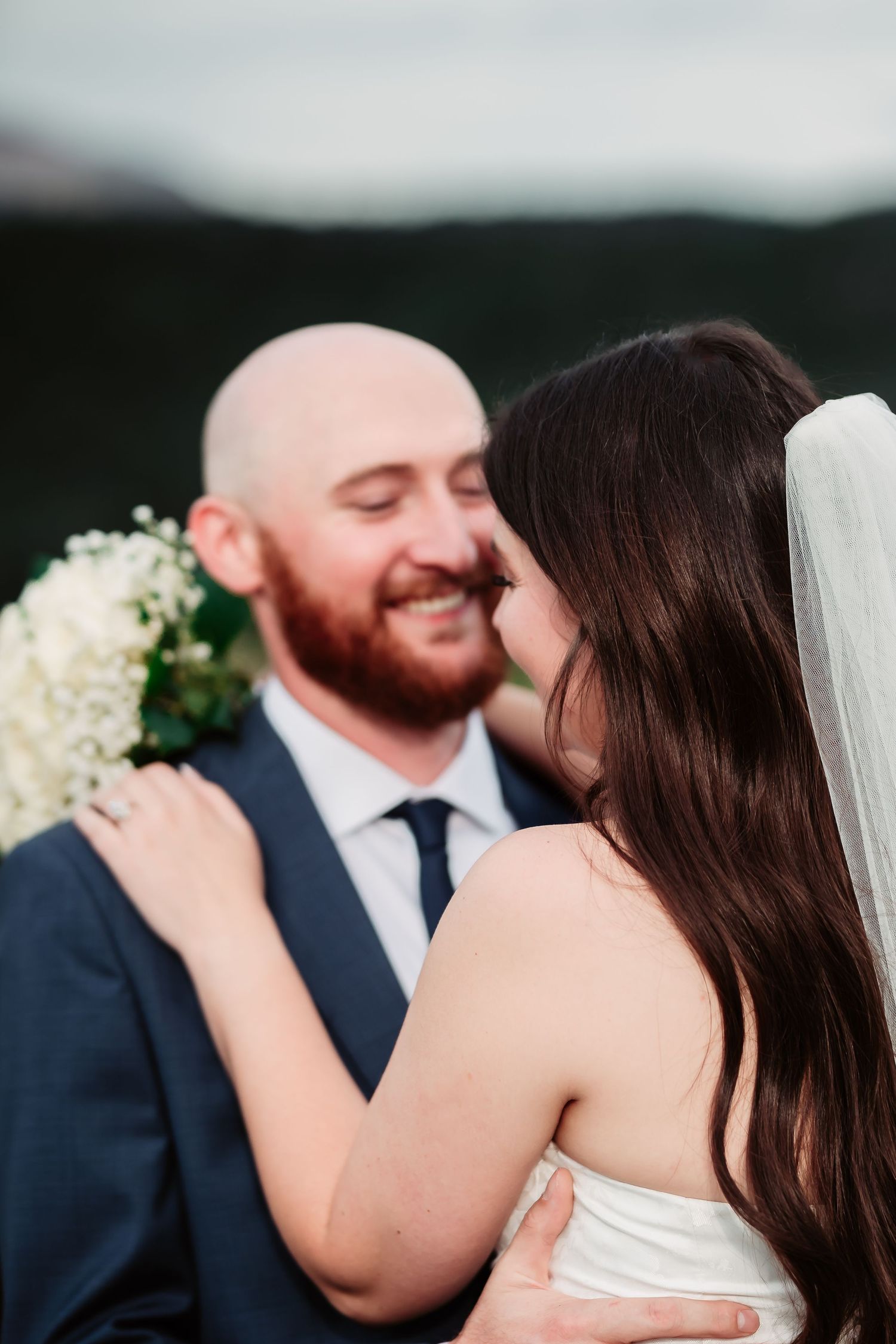 A joyful wedding moment captured against a scenic mountain landscape at sunset.