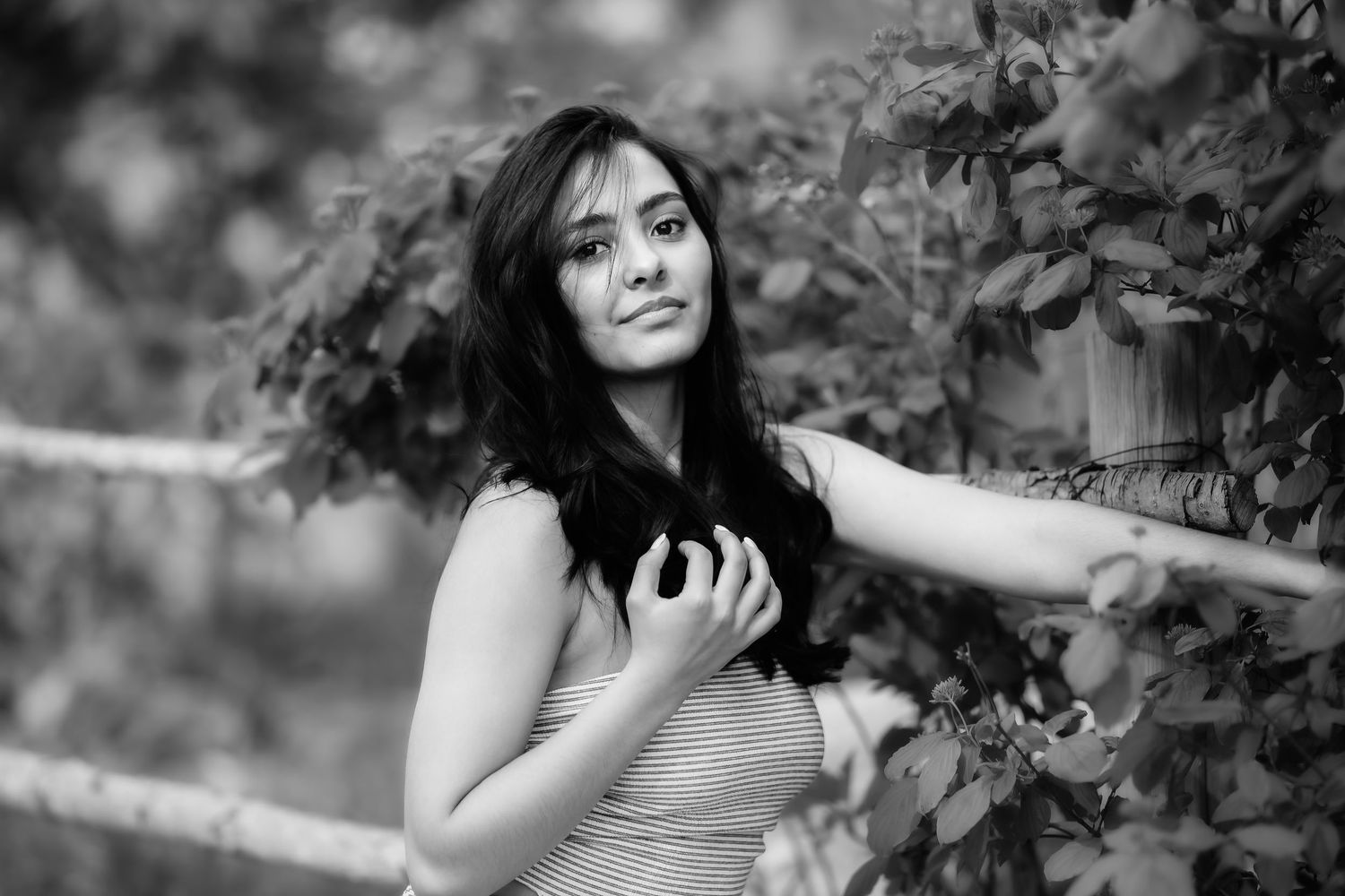 A dreamy black and white portrait among garden foliage.