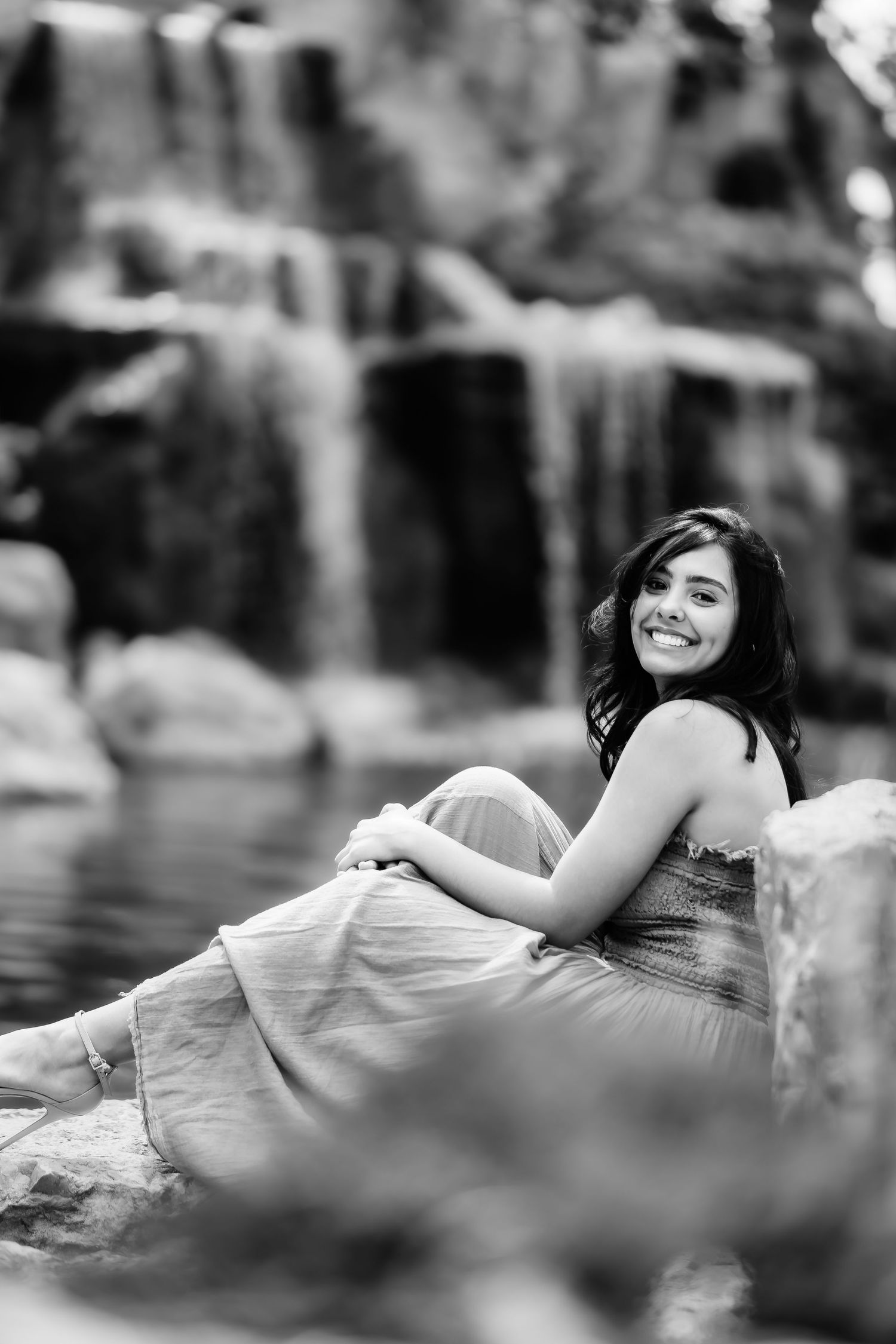 Black and white portrait by waterfall with soft bokeh effect.