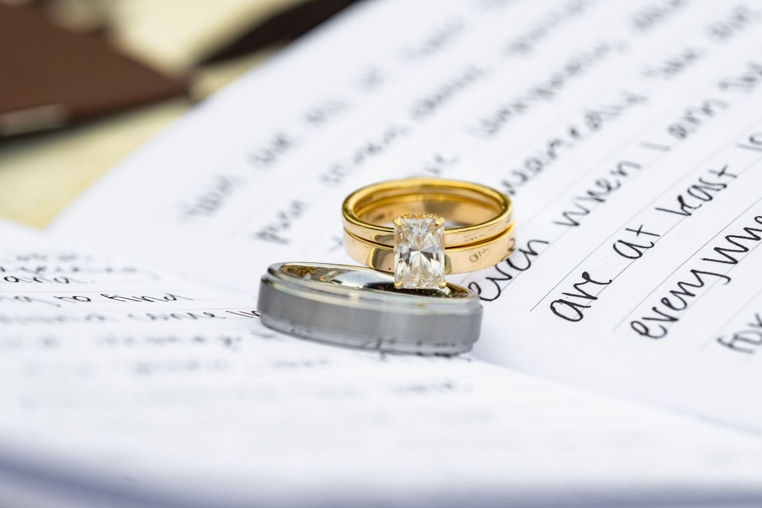 Wedding rings placed on marriage documentation, featuring gold and silver bands with diamonds.