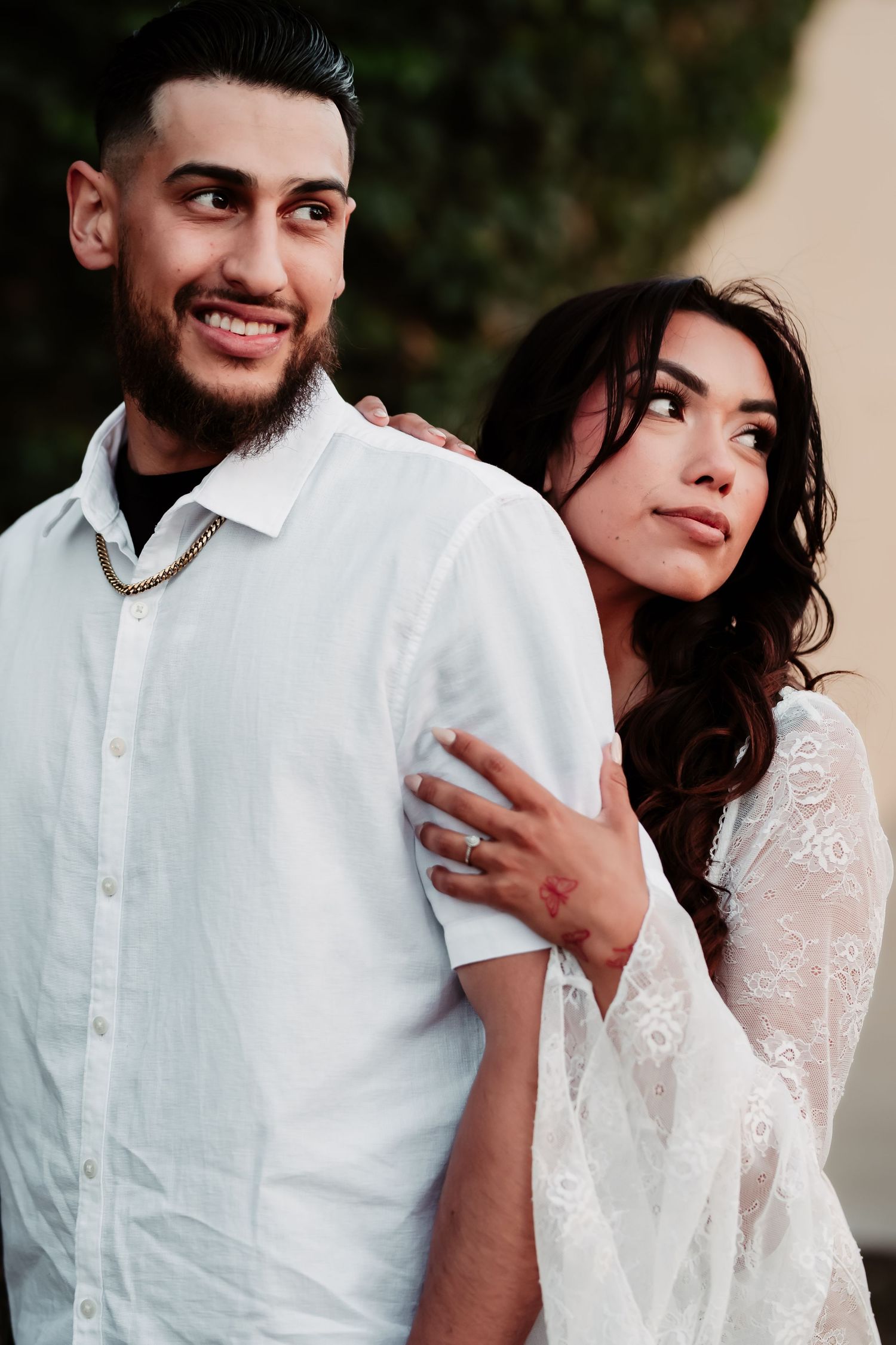 A couple sharing tender moments during an outdoor photo session in white clothing.