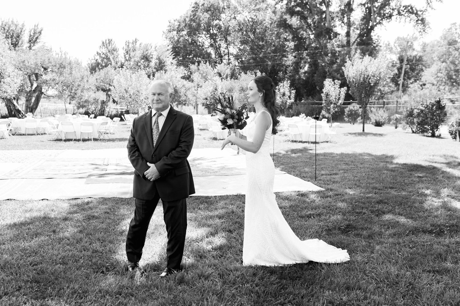 Black and white portrait of bride and groom sharing a candid moment outdoors.