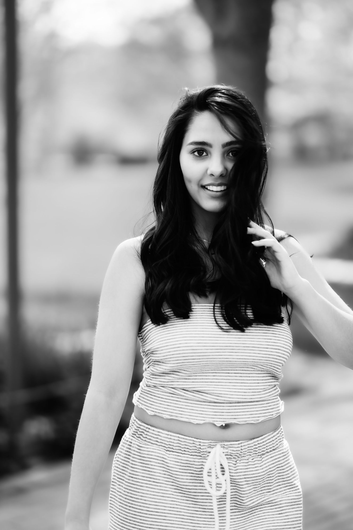 Black and white portrait showing a casual style with striped two-piece outfit outdoors.