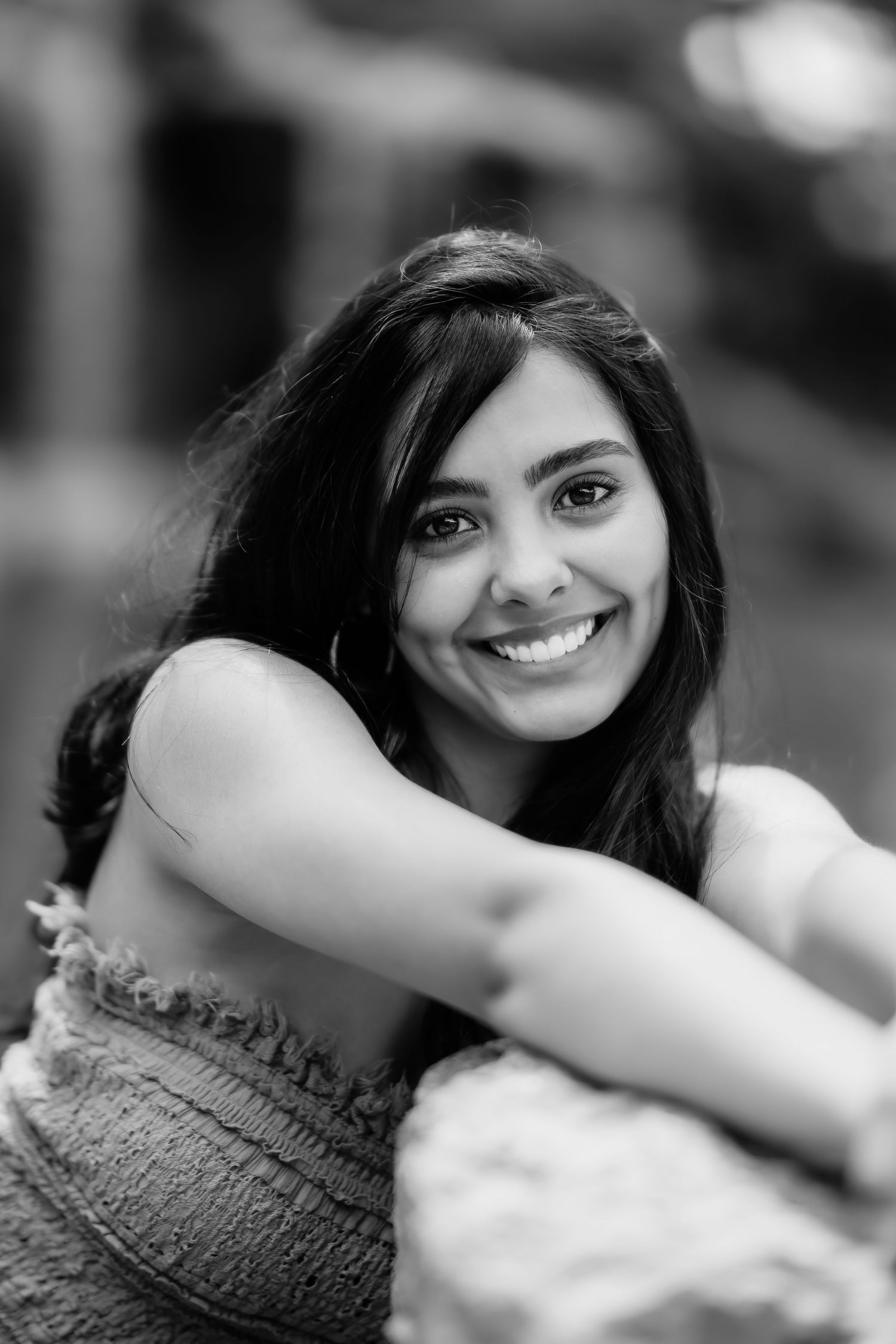 Black and white close up portrait showing bright smile and dark flowing hair.