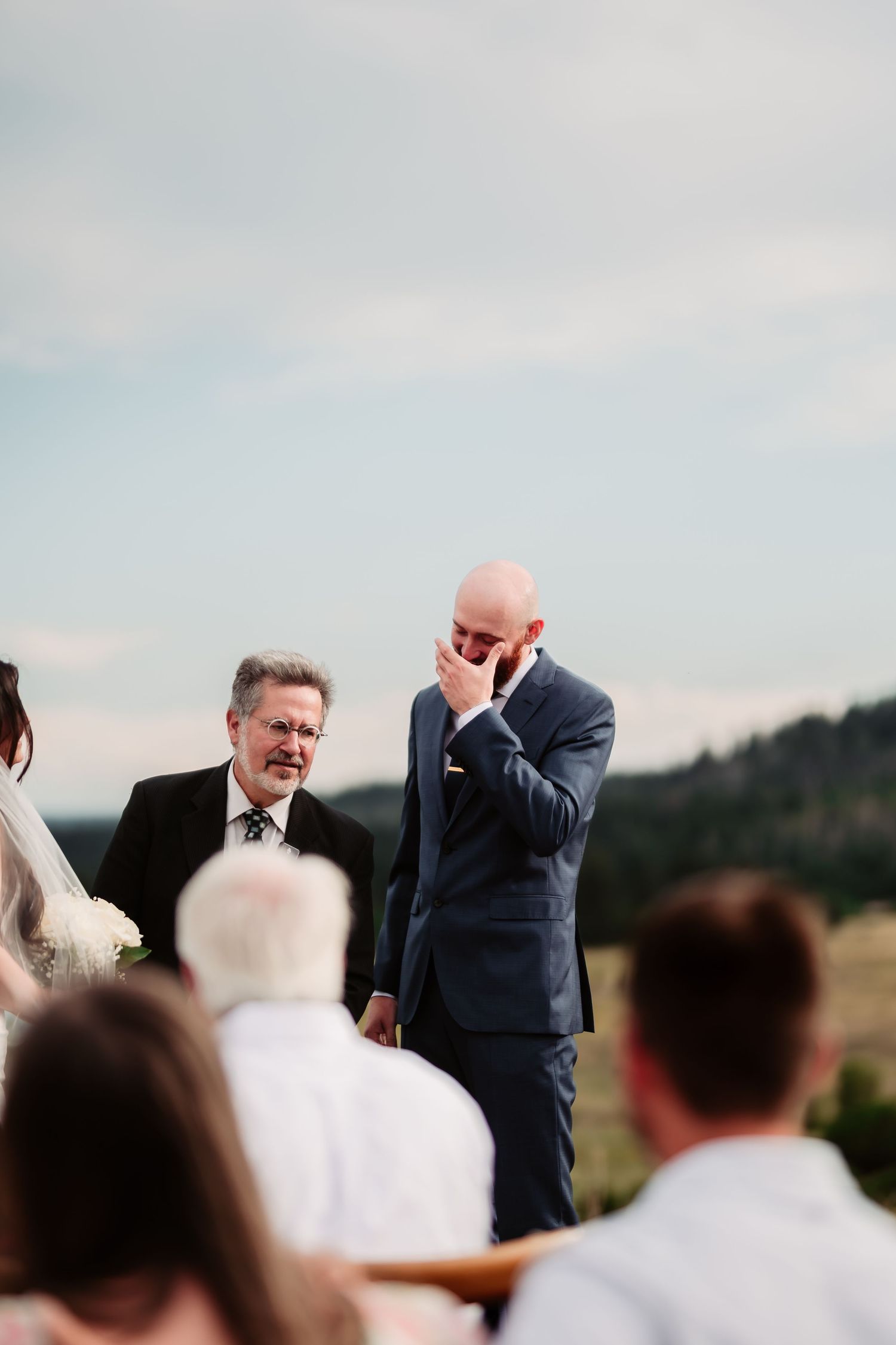 Emotional moment during outdoor wedding ceremony with mountain backdrop.