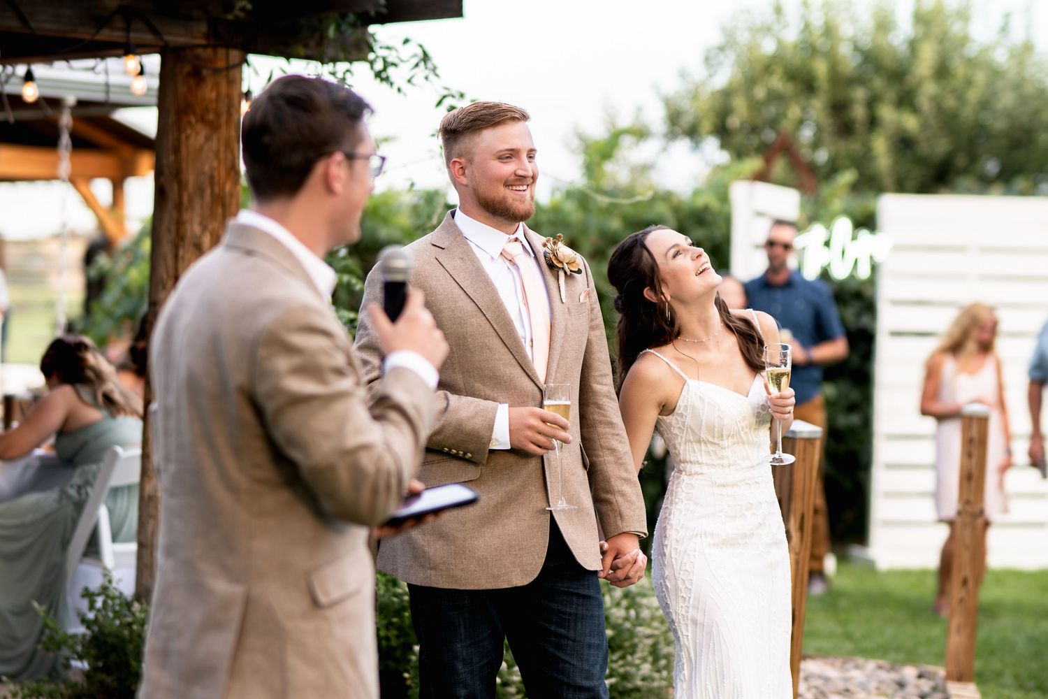 Wedding guests enjoying outdoor reception celebrations on a sunny afternoon.