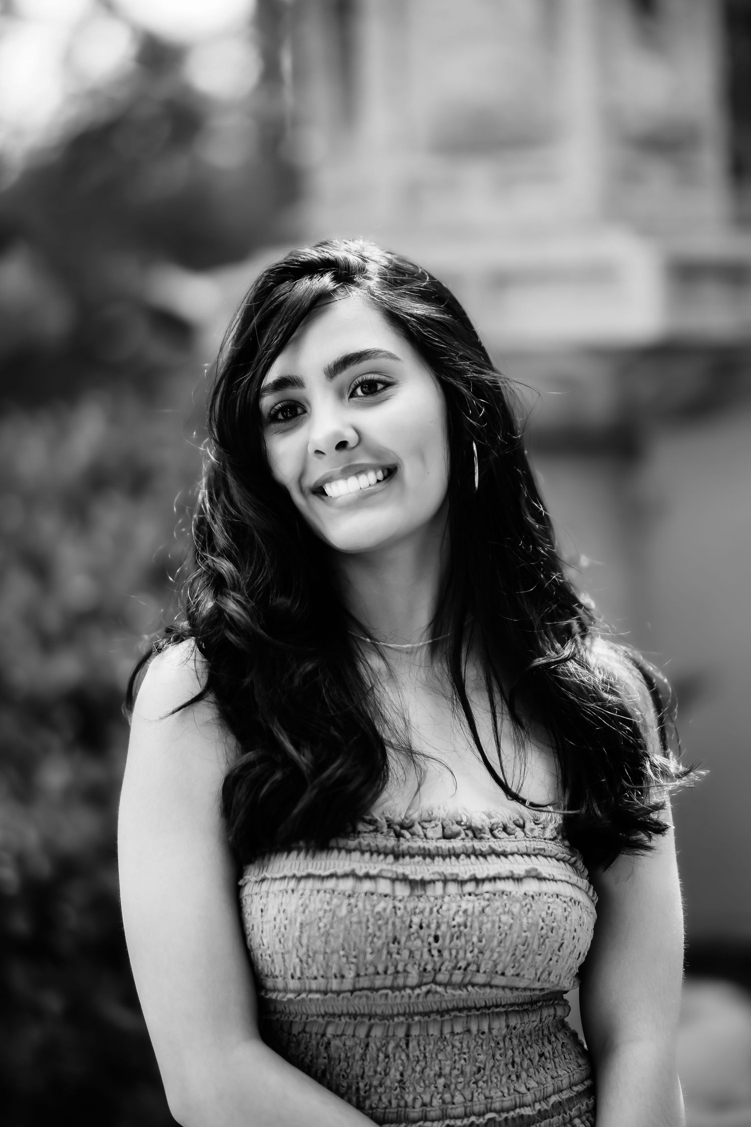 Black and white portrait featuring a strapless top and radiant smile.