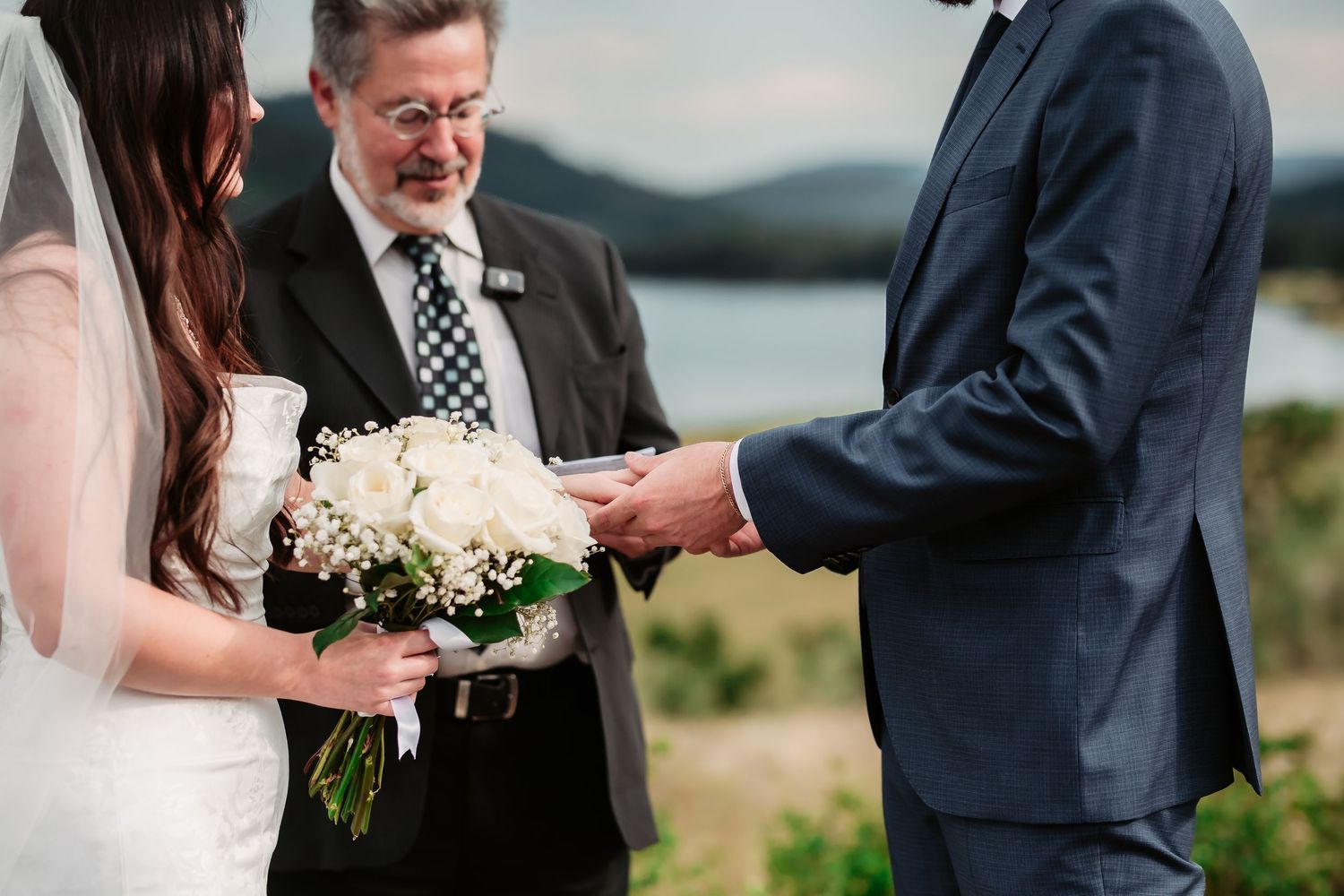 Intimate wedding ceremony moments captured in a natural setting with water views.