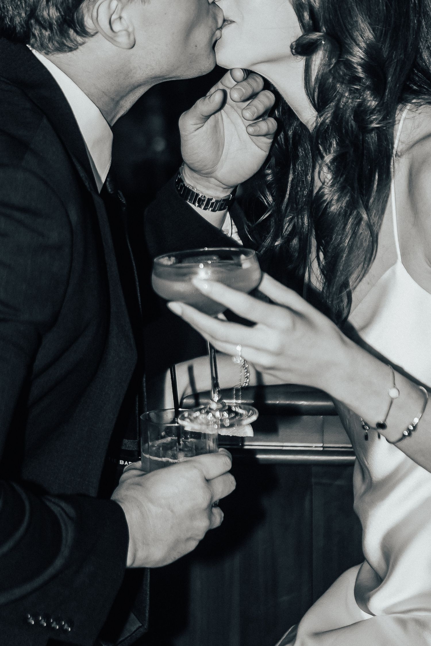 A black and white photo series showing intimate moments at a wedding or formal event.