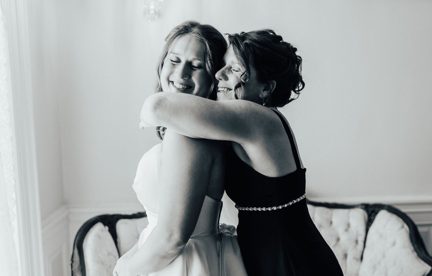 Four bridesmaids in black dresses dance and celebrate at a wedding reception.