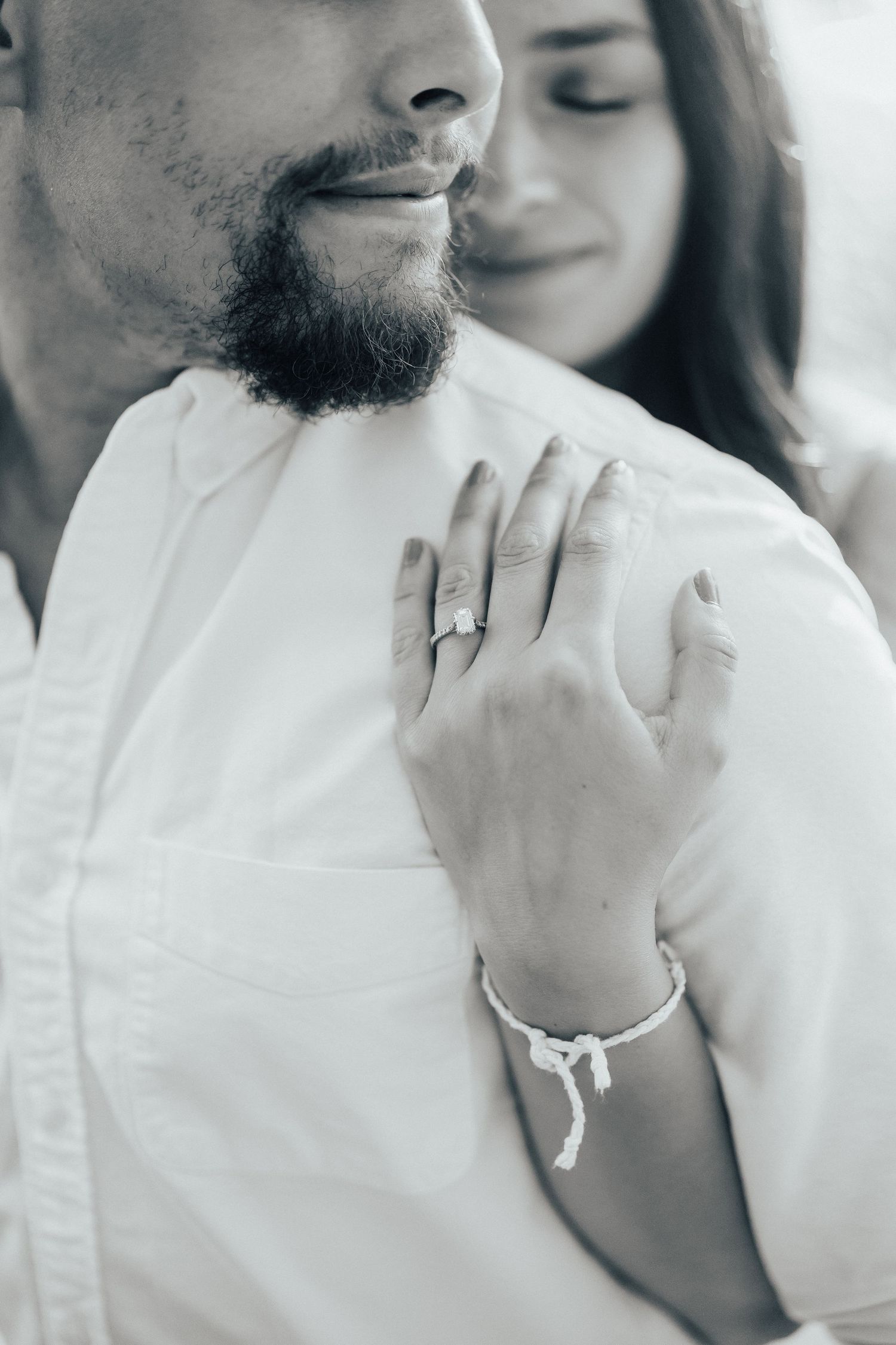 A couple wearing white outfits share an intimate moment in a series of dreamy black and white photographs.
