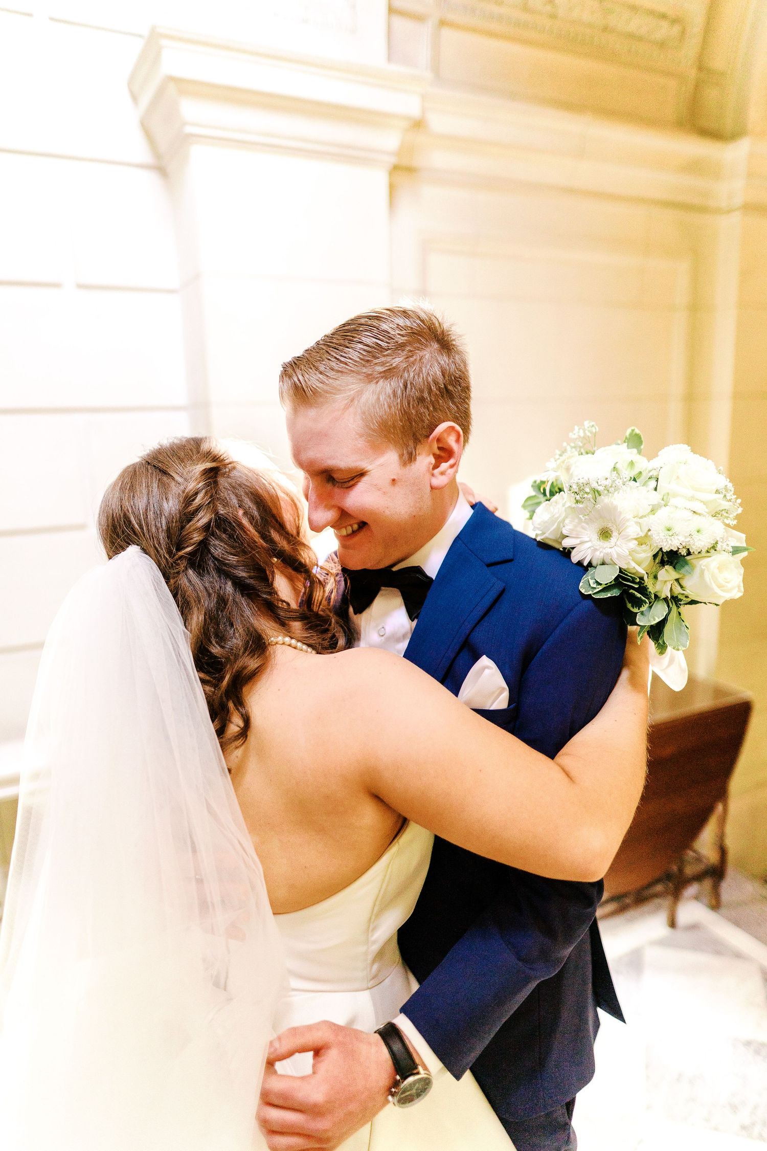 A romantic moment between newlyweds sharing a tender embrace in formal wedding attire.