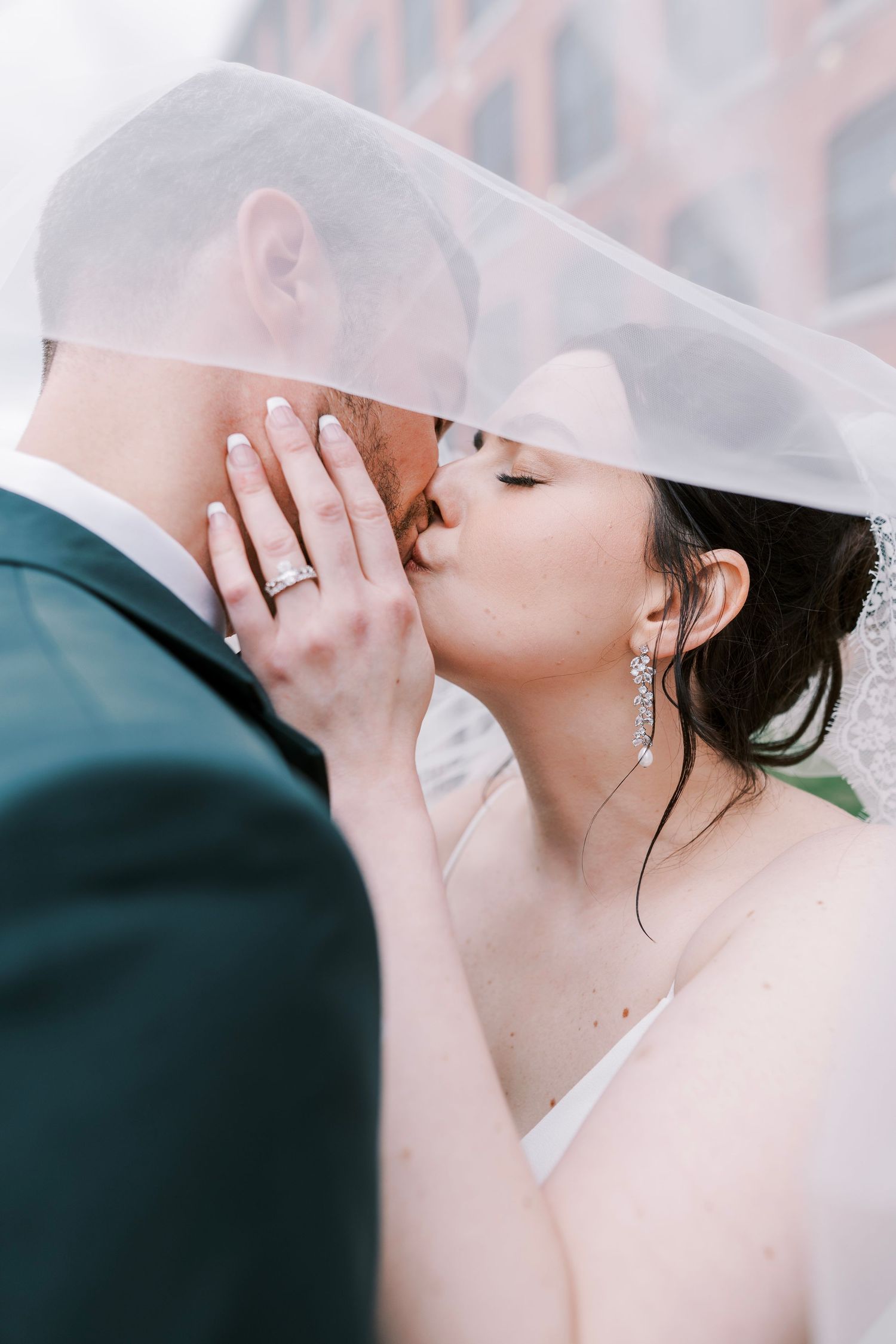 Romantic wedding portrait under a sheer veil.