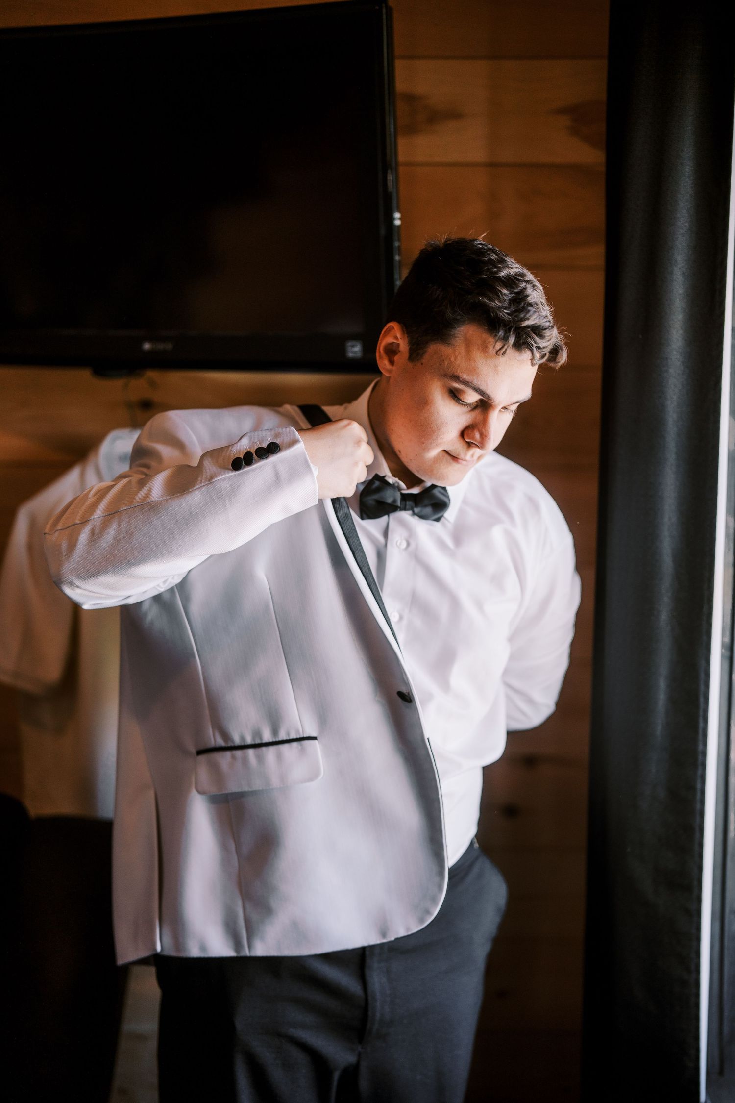A sequence of images shows someone in a classic black and white formal attire adjusting their bow tie.