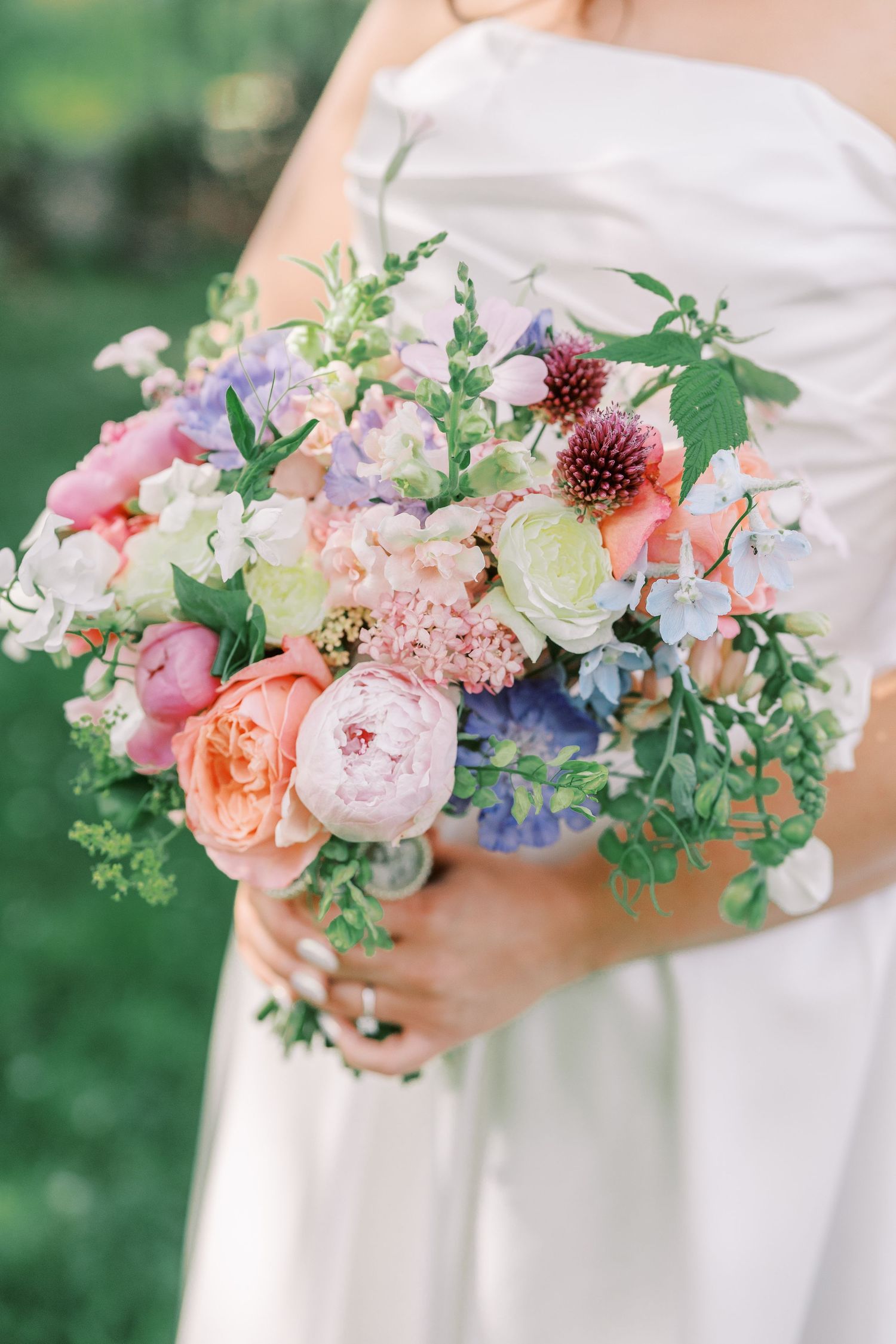 Romantic bridal bouquet with pink peonies, dahlias, and mixed pastel flowers.