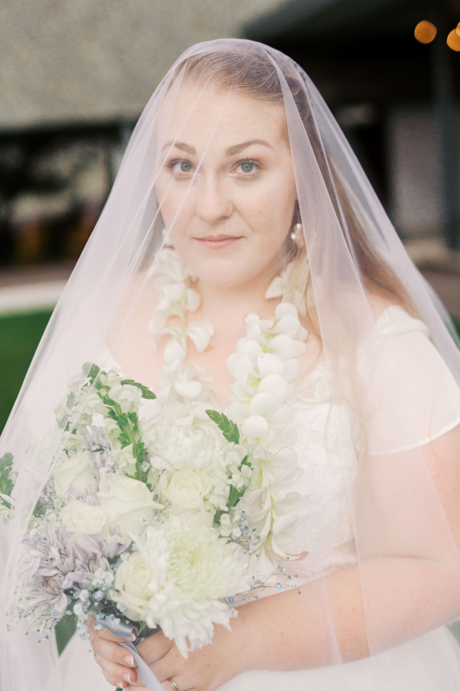 A delicate bridal portrait series featuring white flowers and a traditional veil.