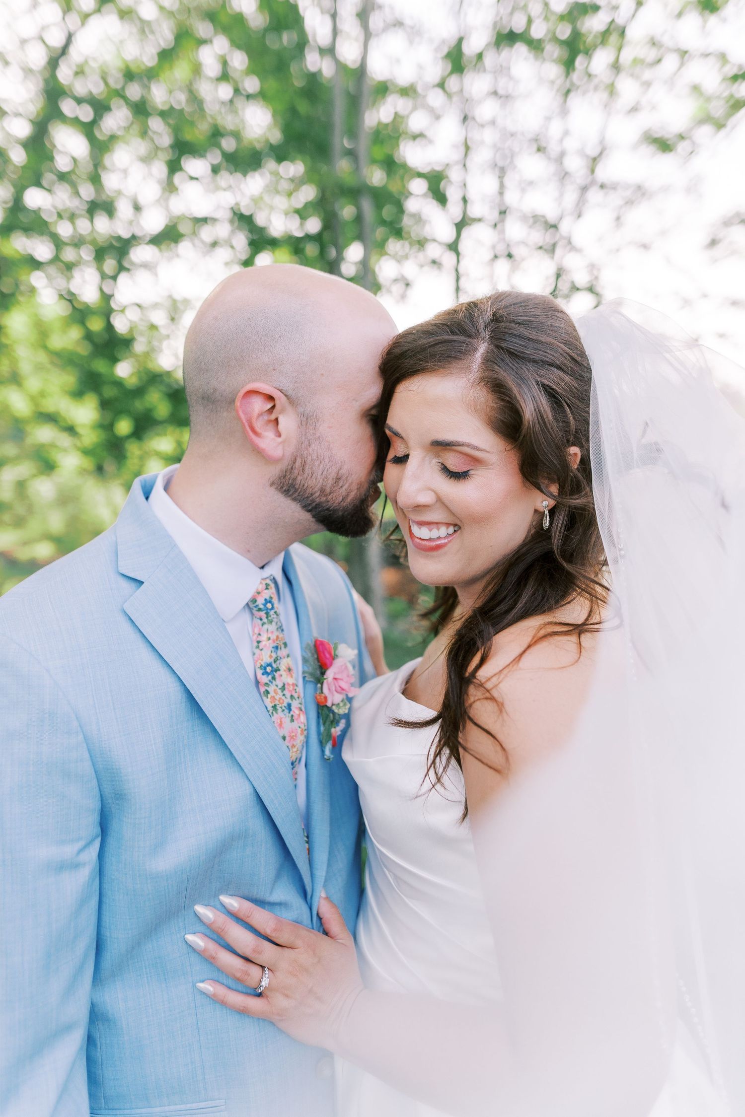 Romantic wedding portrait in soft natural lighting with gentle embraces.