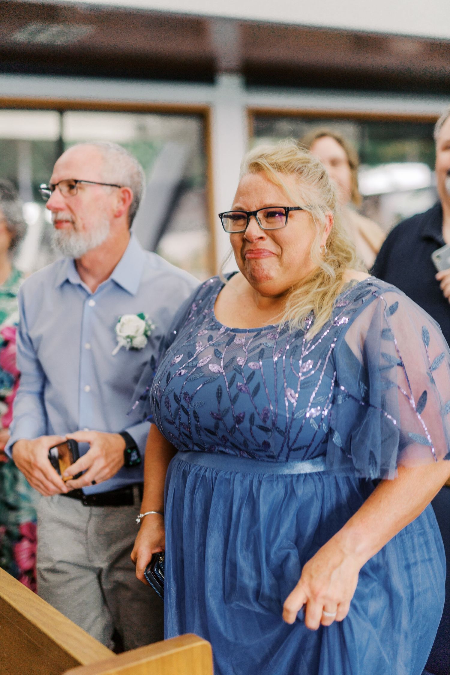 Wedding guests in formal attire watching ceremony proceedings.