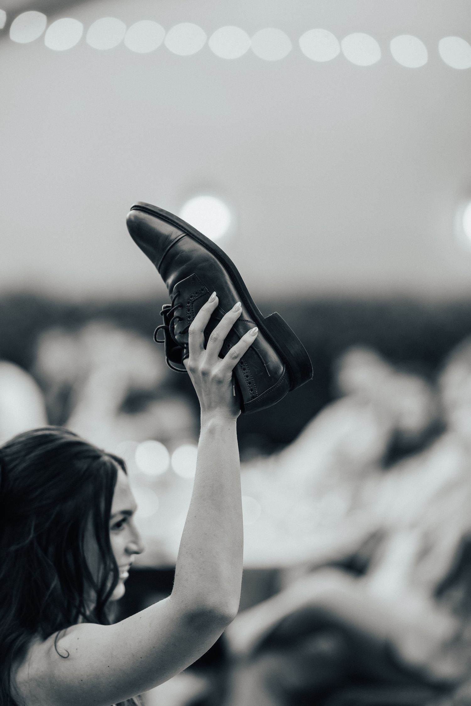 Multiple overlapping shots show hands lifted up high in a crowd holding hats in silhouette against a blurred background.